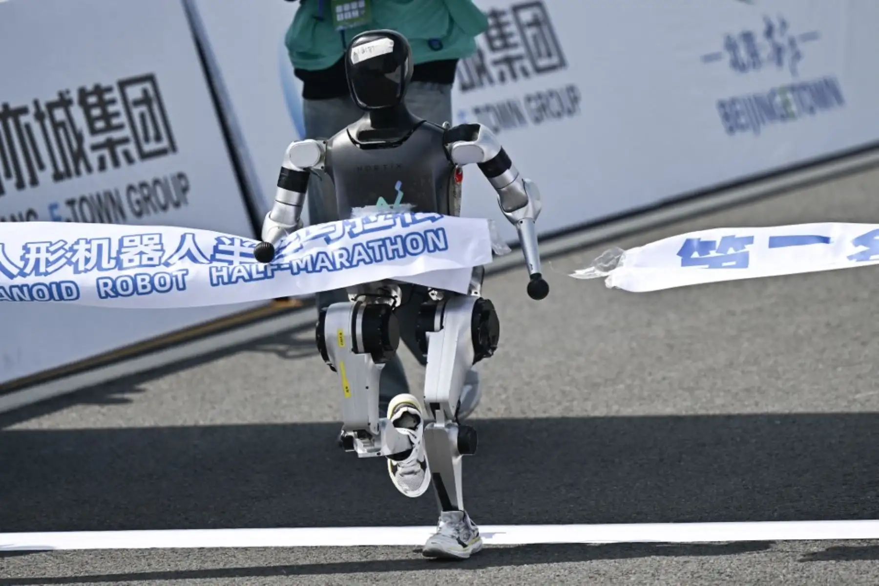 Un robot cruza la línea de meta en la media maratón de robots humanoides en Beijing el 19 de abril de 2025. Decenas de robots humanoides salieron a las calles de Beijing, uniéndose a miles de participantes humanos en una media maratón pionera en el mundo que muestra el impulso de China para liderar la carrera mundial en tecnología de vanguardia. Foto: AFP