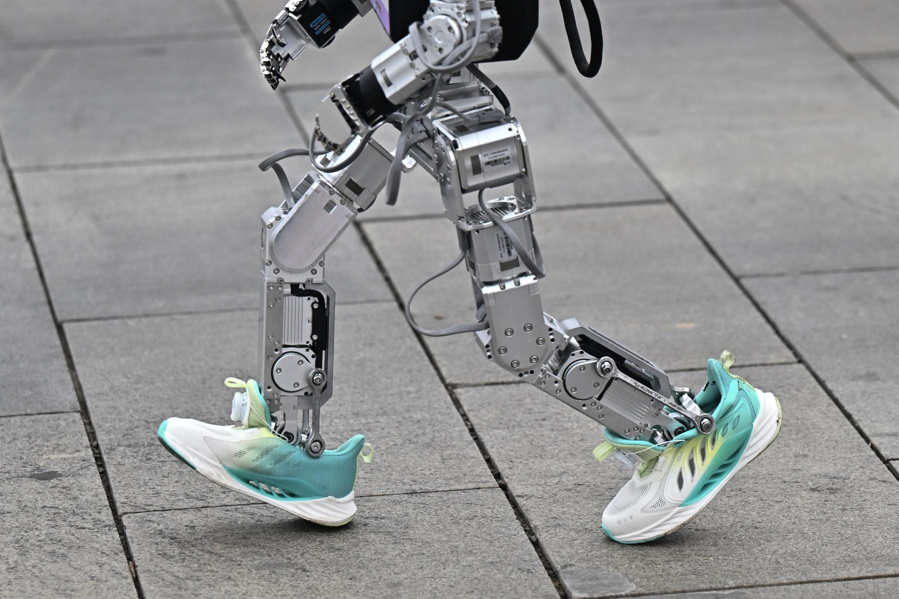 Un robot corre en la media maratón de robots humanoides en Beijing el 19 de abril de 2025. Decenas de estos robots salieron a las calles de Beijing, uniéndose a miles de participantes humanos en una media maratón pionera en el mundo que muestra el impulso de China para liderar la carrera mundial en tecnología de vanguardia. Foto: AFP
