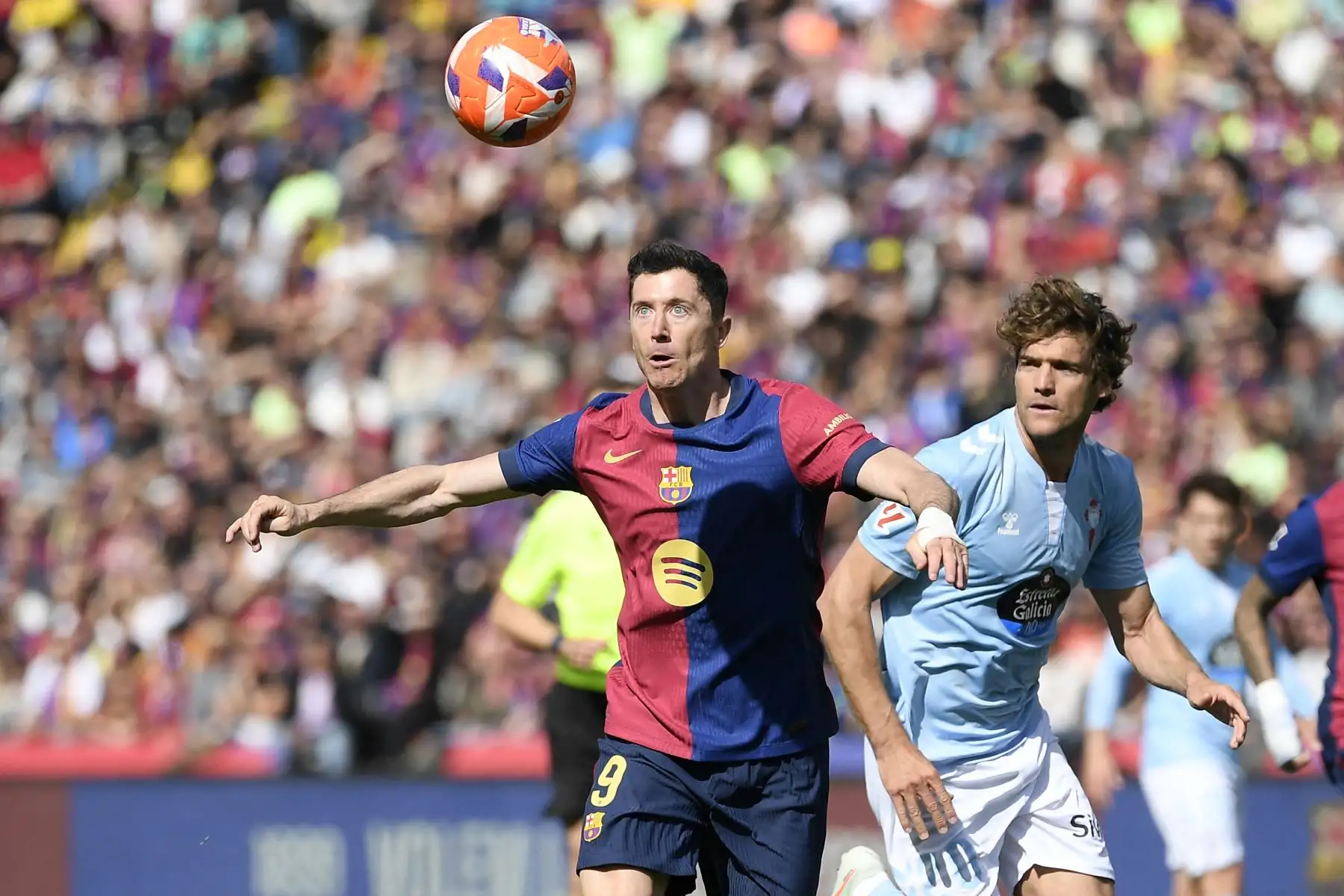 El delantero polaco del Barcelona, Robert Lewandowski, y el defensa español del Celta de Vigo, Marcos Alonso Mendoza, compiten por el balón durante el partido de fútbol de la liga española entre el FC Barcelona y el RC Celta de Vigo en el Estadi Olimpic Lluis Companys de Barcelona el 19 de abril de 2025. Foto: AFP