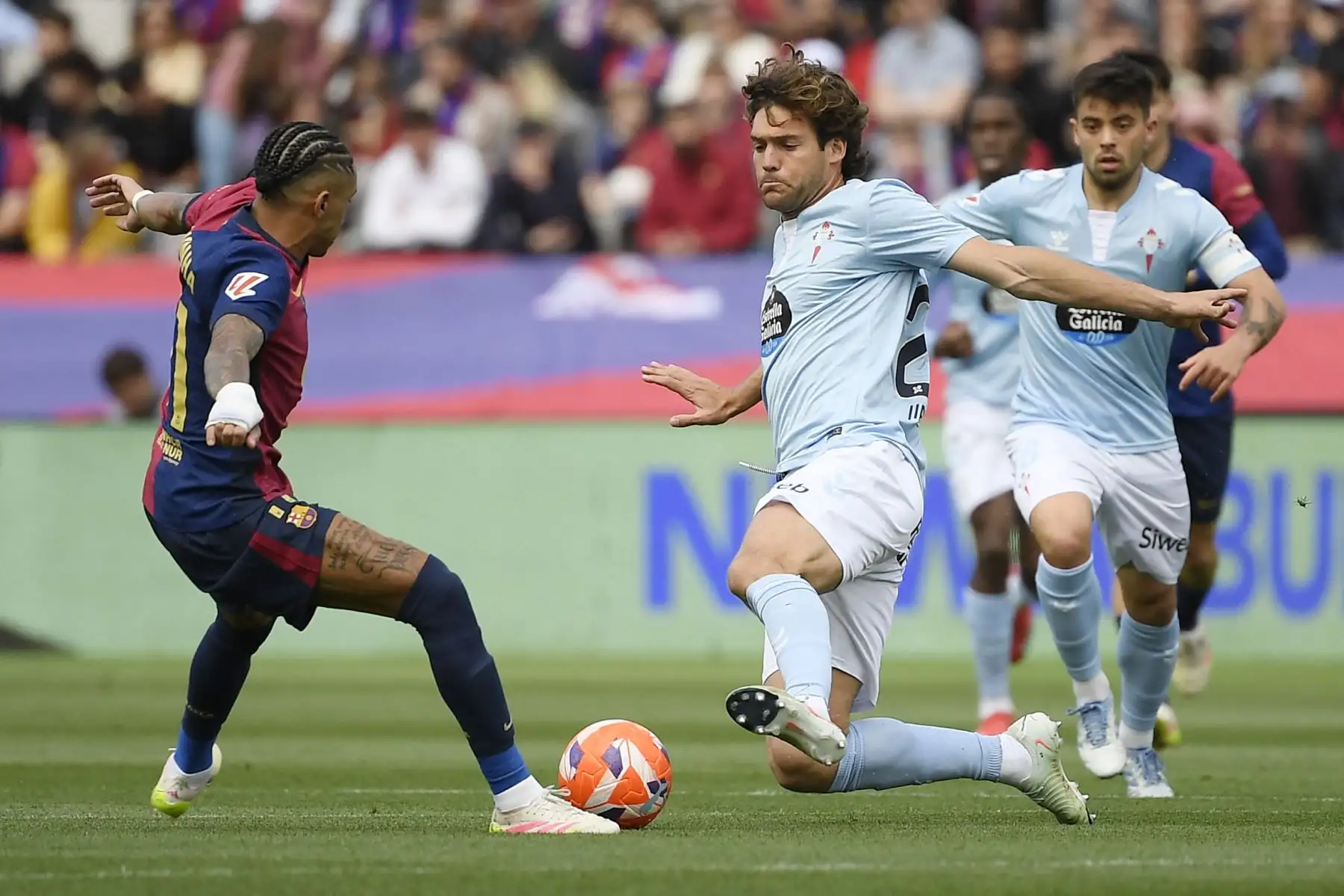 El delantero brasileño del Barcelona, Raphinha, y el defensa español del Celta de Vigo, Marcos Alonso Mendoza, compiten por el balón durante el partido de fútbol de la liga española entre el FC Barcelona y el RC Celta de Vigo en el Estadi Olimpic Lluis Companys de Barcelona el 19 de abril de 2025.Foto: AFP