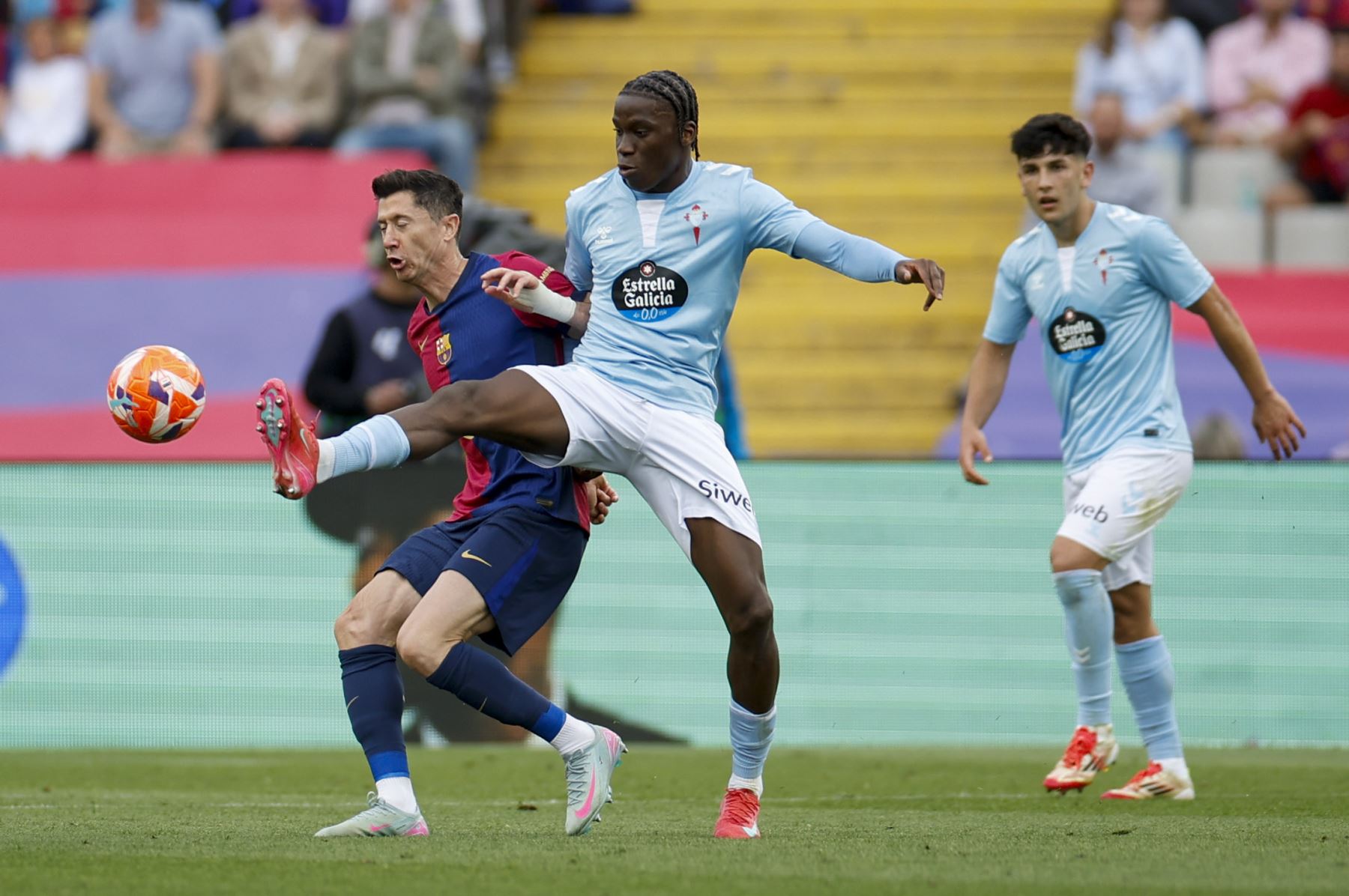 El centrocampista del Celta de Vigo, Ilaix Moriba, disputa el balón con Robert Lewandowski del FC Barcelona, durante el partido de la jornada 32 de LaLiga EA Sports que FC Barcelona y Celta de Vigo disputan este sábado en el estadio olímpico Lluís Companys en Barcelona. Foto: EFE