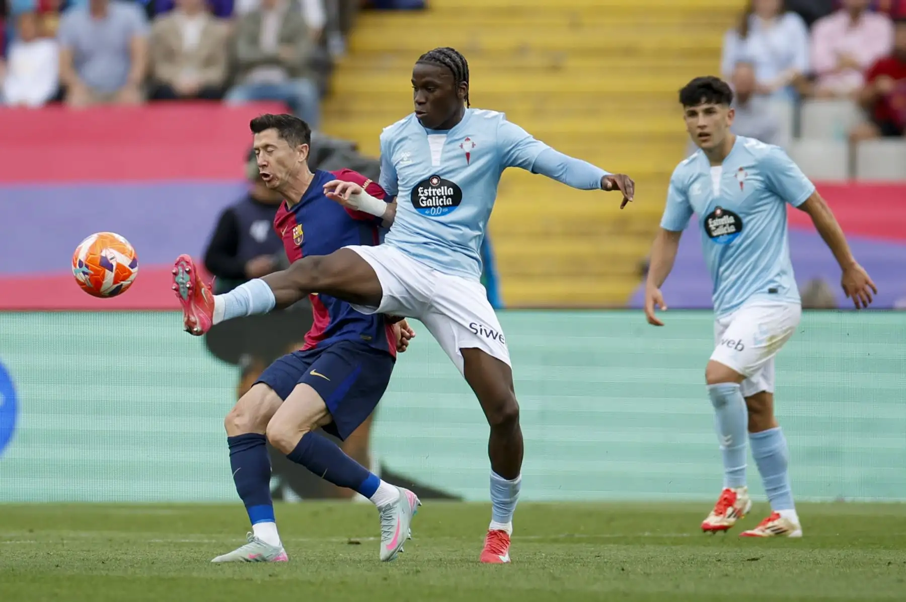 El centrocampista del Celta de Vigo, Ilaix Moriba, disputa el balón con Robert Lewandowski del FC Barcelona, durante el partido de la jornada 32 de LaLiga EA Sports que FC Barcelona y Celta de Vigo disputan este sábado en el estadio olímpico Lluís Companys en Barcelona. Foto: EFE