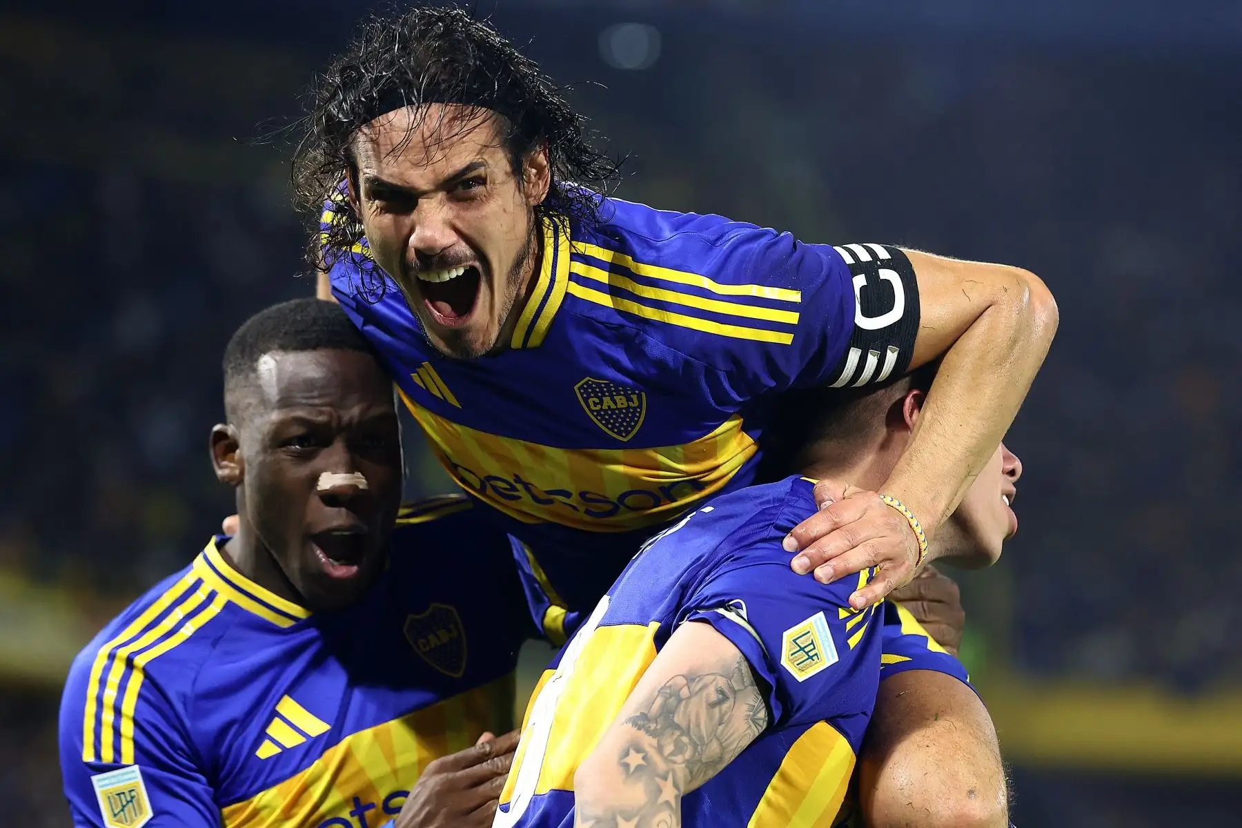 El centrocampista chileno de Boca Juniors Carlos Palacios celebra con sus compañeros el delantero uruguayo Edinson Cavani y el defensa peruano  Luis Advíncula tras anotar durante el partido del Torneo Apertura 2025 de la Liga Profesional de Fútbol Argentino entre Boca Juniors y Estudiantes de La Plata. Foto: ANDINA/AFP