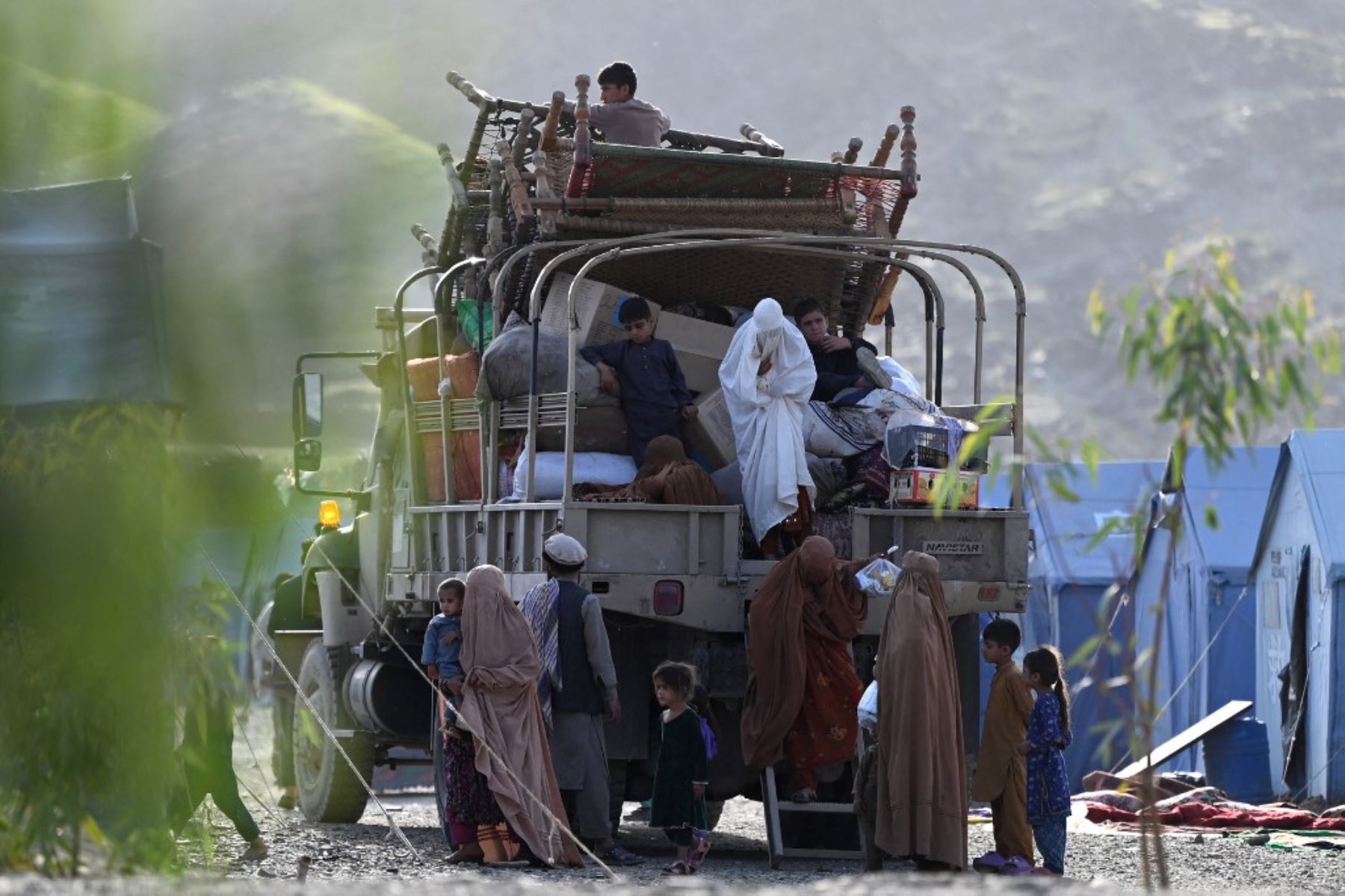 Refugiados afganos bajan de un camión tras llegar desde Pakistán cerca de la frontera entre Afganistán y Pakistán en Torkham, en la provincia de Nangarhar, el 20 de abril de 2025. Pakistán ha lanzado una estricta campaña para desalojar antes de fin de mes a más de 800 mil afganos cuyos permisos de residencia han sido cancelados. Foto: AFP