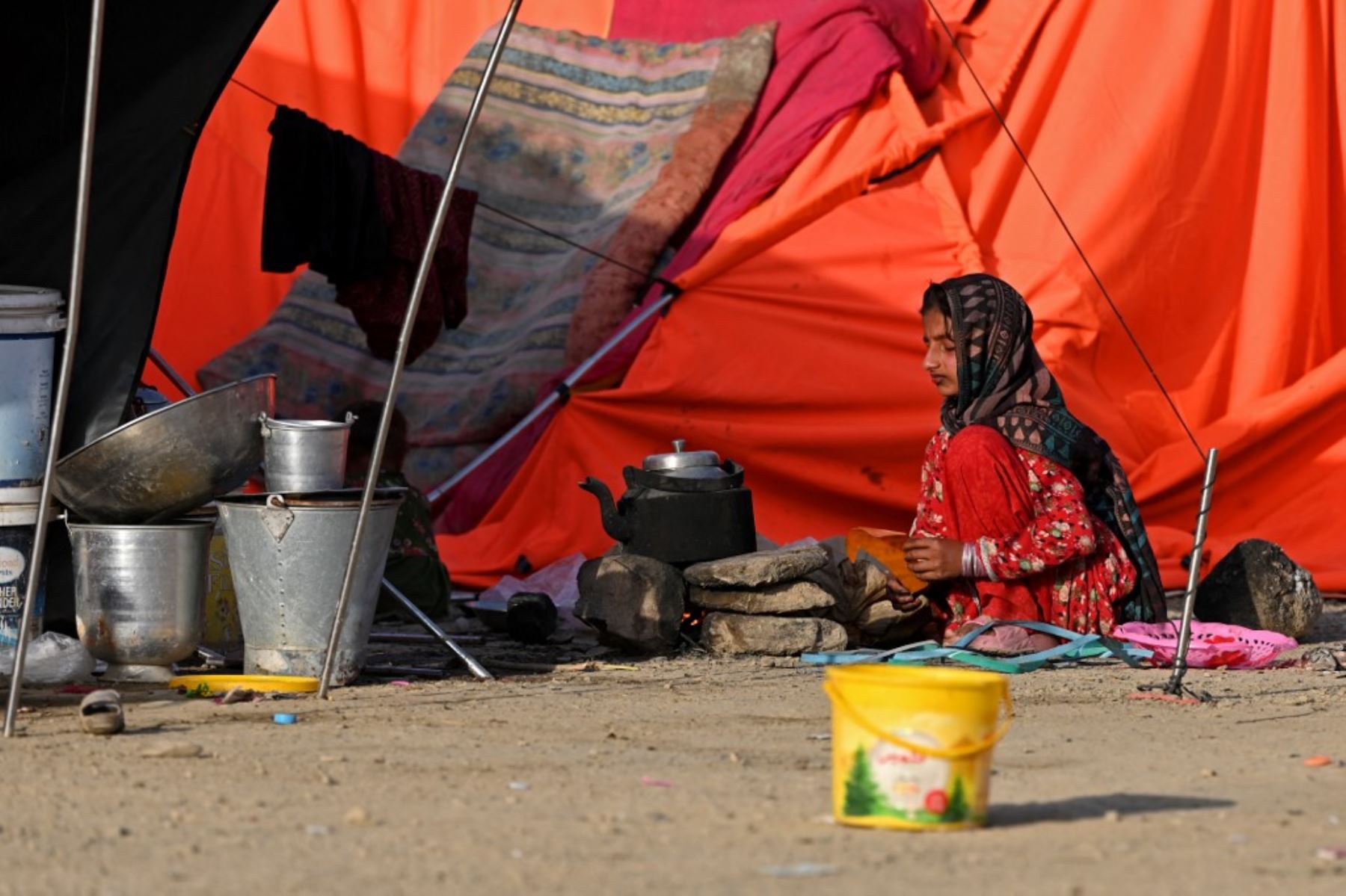 Una niña refugiada afgana prepara té afuera de su tienda de campaña tras llegar desde Pakistán a un campamento improvisado cerca de la frontera entre Afganistán y Pakistán en Torkham, en la provincia de Nangarhar, el 20 de abril de 2025. Foto: AFP