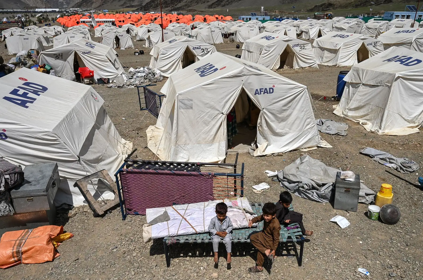 Niños refugiados afganos se sientan afuera de sus tiendas de campaña en un campamento improvisado de la Presidencia de Gestión de Desastres y Emergencias (AFAD) después de su llegada de Pakistán cerca de la frontera entre Afganistán y Pakistán en Torkham, en la provincia de Nangarhar. Foto: AFP