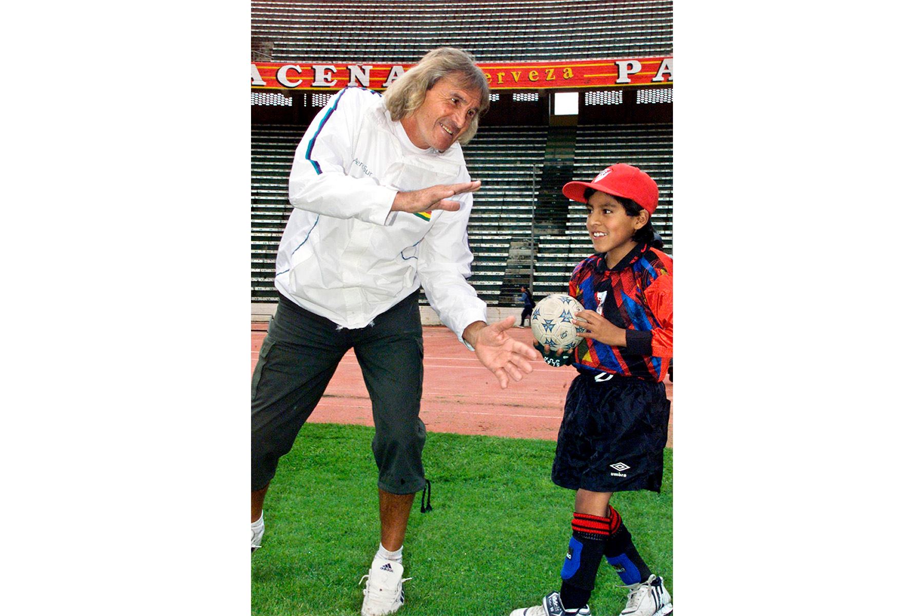 El arquero argentino Hugo Orlando Gatti bromea con un niño el 22 de enero de 2004 en el estadio Hernando Siles de La Paz, Bolivia. Gatti visita Bolivia para promocionar el torneo de verano de fútbol que organiza una línea aérea boliviana. Foto: AFP