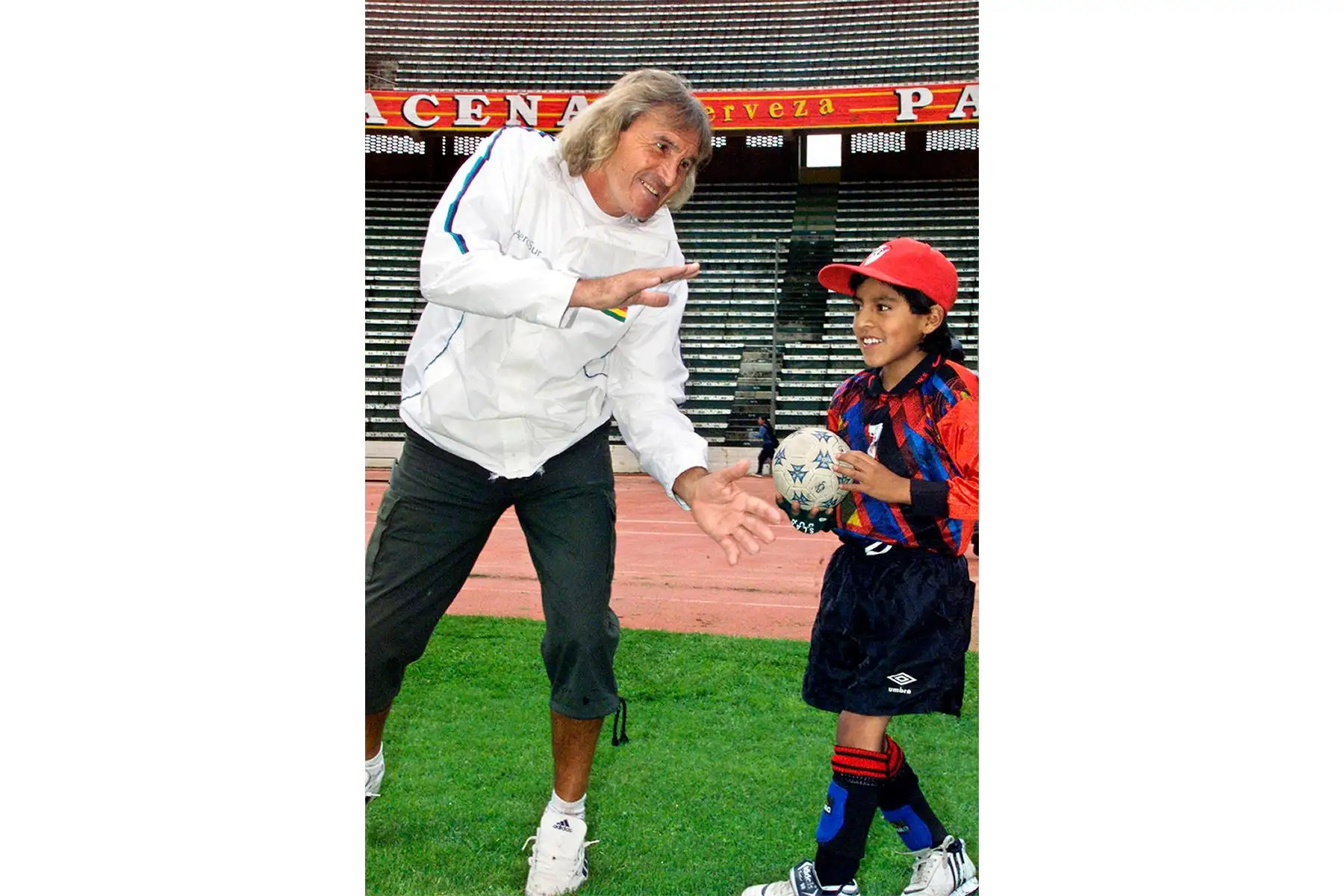 El arquero argentino Hugo Orlando Gatti bromea con un niño el 22 de enero de 2004 en el estadio Hernando Siles de La Paz, Bolivia. Gatti visita Bolivia para promocionar el torneo de verano de fútbol que organiza una línea aérea boliviana. Foto: AFP