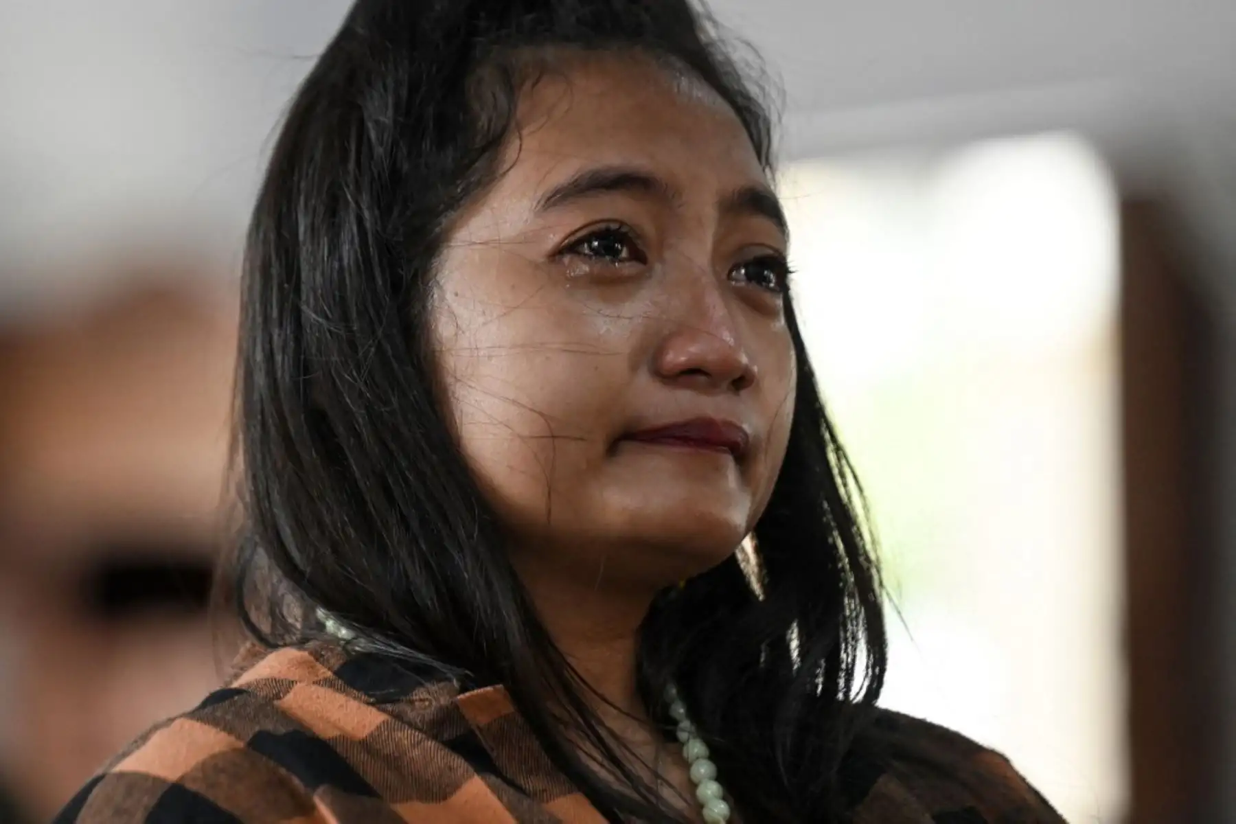 Una mujer reacciona mientras los fieles católicos se reúnen para rezar en memoria del papa Francisco en la iglesia del Santísimo Redentor de Bangkok el 21 de abril de 2025. Foto: AFP