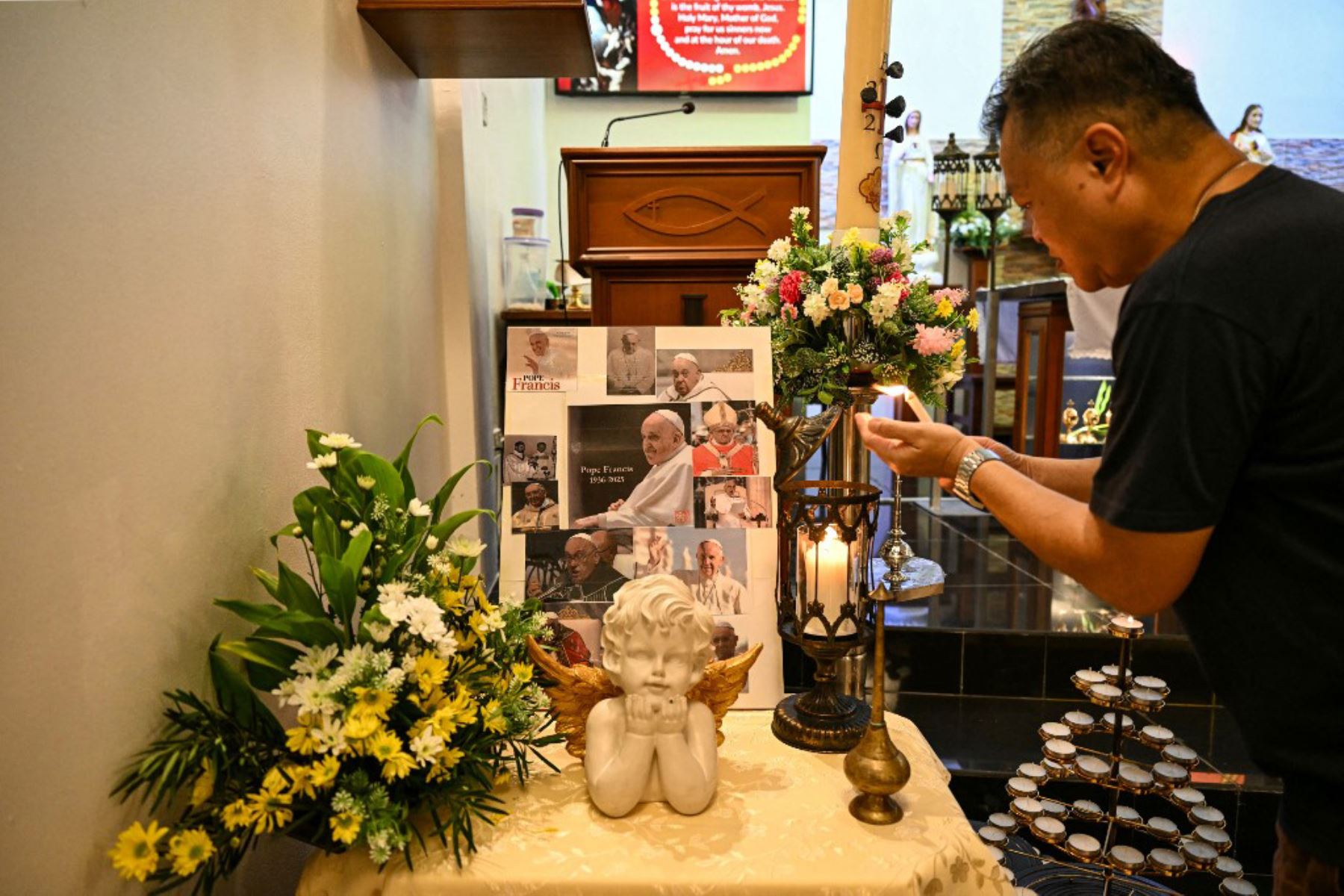 El Padre Clemente de Malasia enciende una vela antes de una misa en memoria del Papa Francisco en la Iglesia del Sagrado Corazón de Bentong el 21 de abril de 2025. Foto: AFP