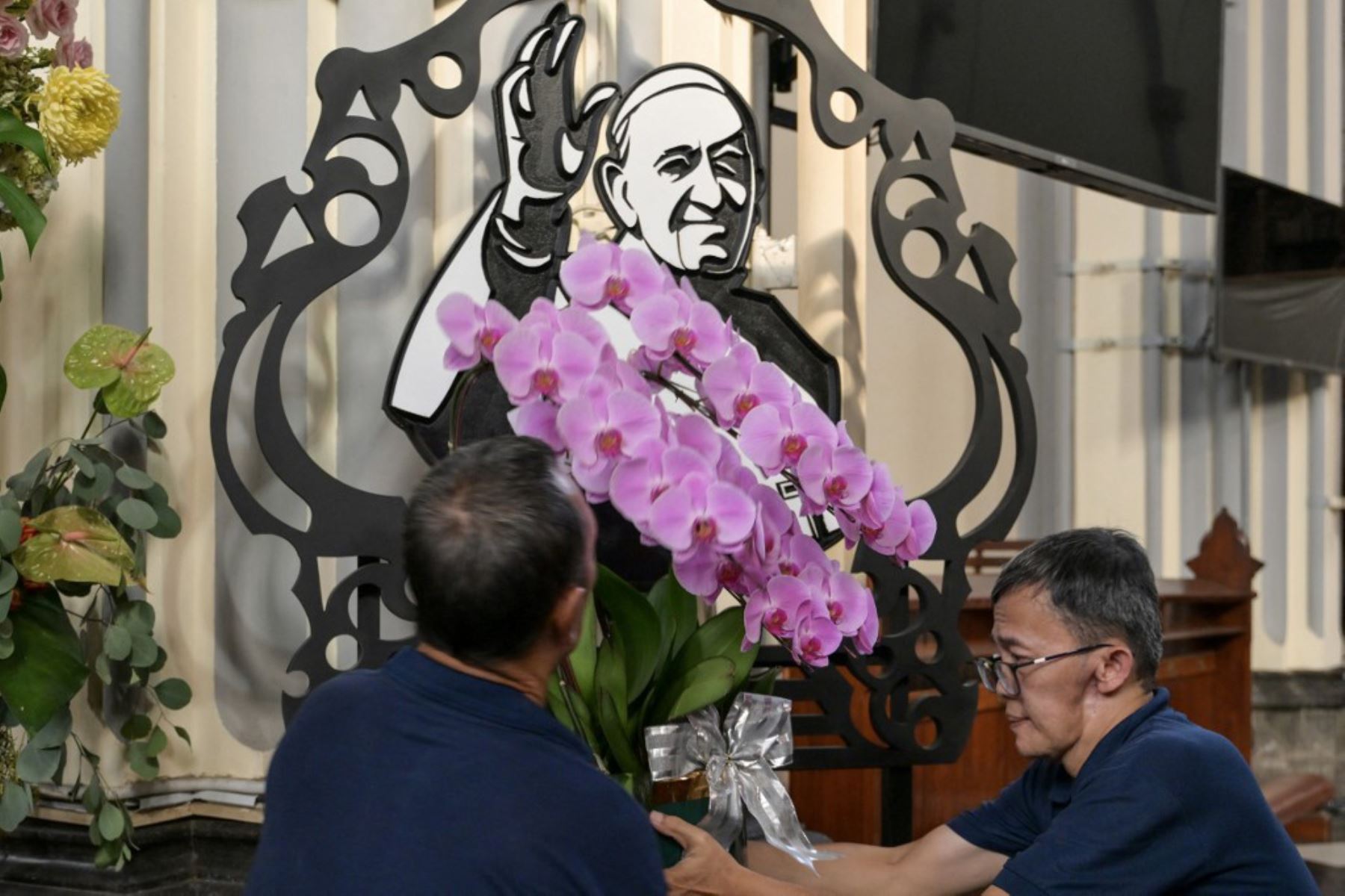 Un retrato del Papa Francisco se ve mientras las autoridades eclesiásticas realizan preparativos en la Catedral de Yakarta el 21 de abril de 2025, tras su fallecimiento en el Vaticano. Foto: AFP