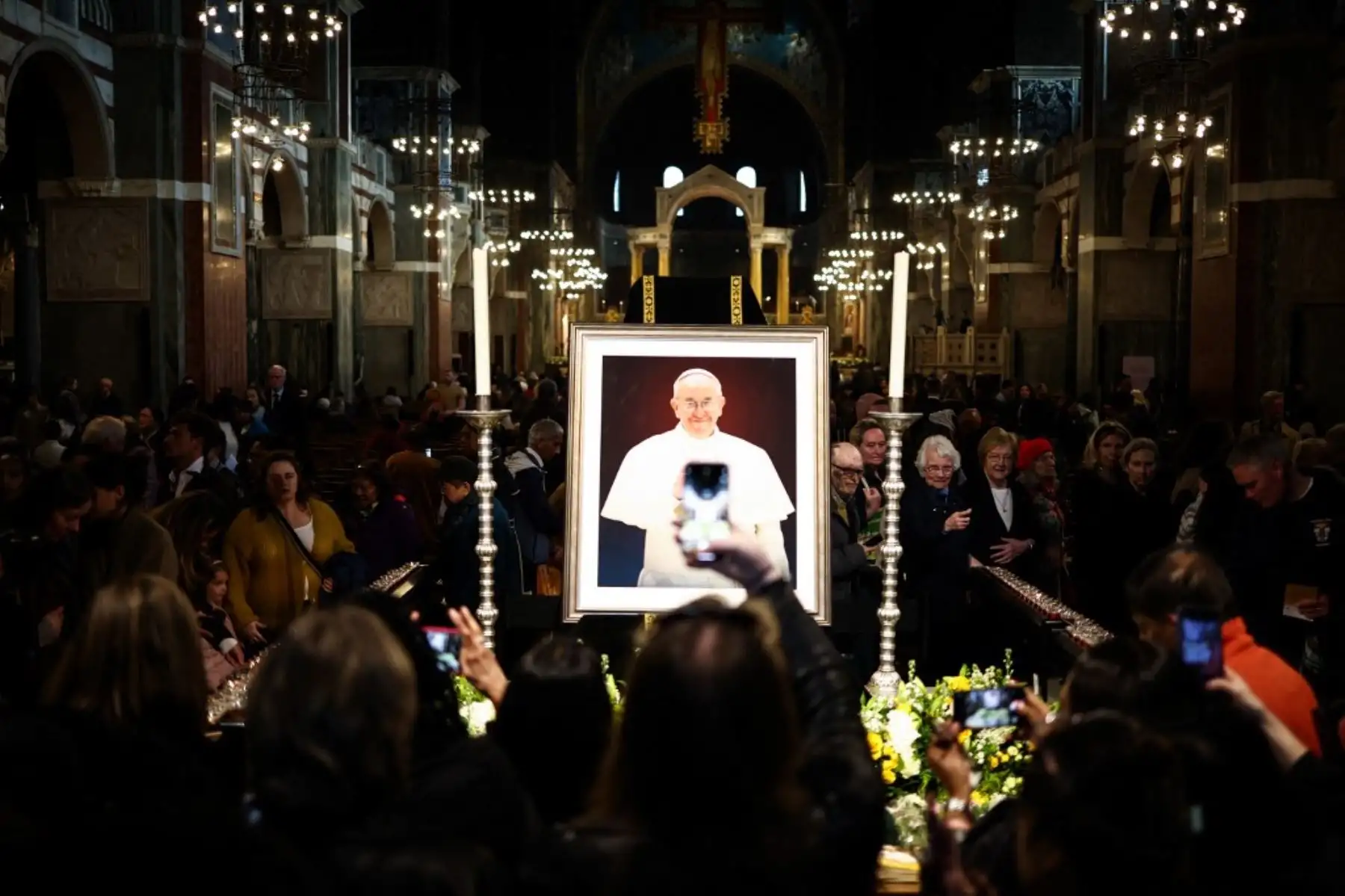 Los fieles toman fotografías del retrato del Papa Francisco exhibido durante el solemne réquiem en la Catedral Metropolitana de la Preciosísima Sangre, conocida informalmente como la Catedral de Westminster, en el centro de Londres. Foto: AFP