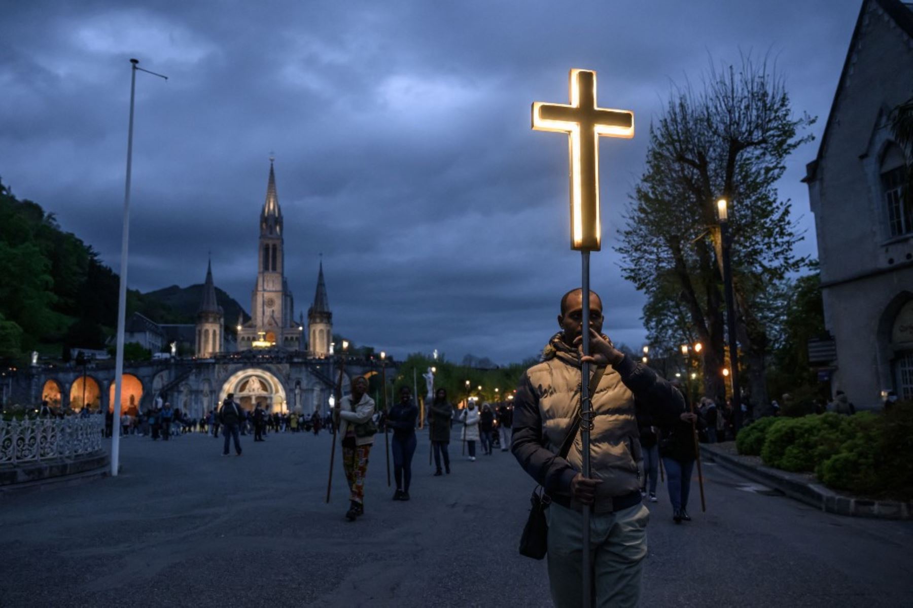 Fieles participan en un desfile de antorchas y un servicio de oración tras la muerte del Papa Francisco, afuera del Santuario de Notre Dame en Lourdes, sur de Francia, el 21 de abril de 2025. Foto: AFP