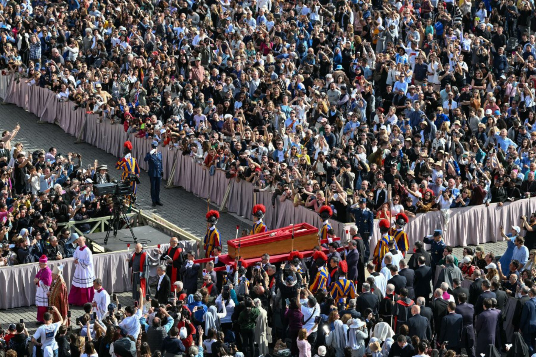 El féretro del papa Francisco es llevado en procesión hacia la basílica de San Pedro, acompañado por cardenales y guardias suizos, mientras suenan las campanas del Vaticano.
Foto: AFP