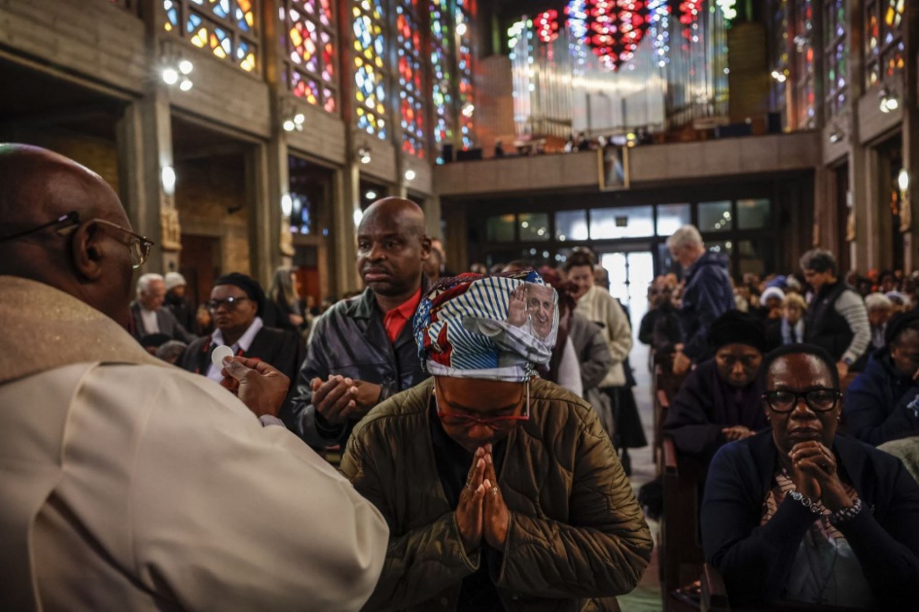 Los católicos reciben la sagrada comunión durante una misa conmemorativa especial para orar por el papa Francisco en la Catedral de Cristo Rey, en Johannesburgo, el 23 de abril de 2025. Foto: AFP