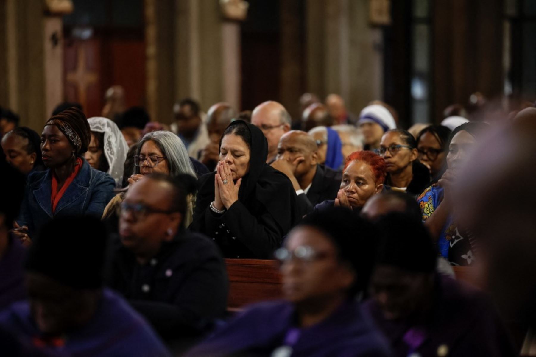 Católicos rezan durante una misa conmemorativa especial por el difunto papa Francisco en la Catedral de Cristo Rey, en Johannesburgo, el 23 de abril de 2025. Foto: AFP