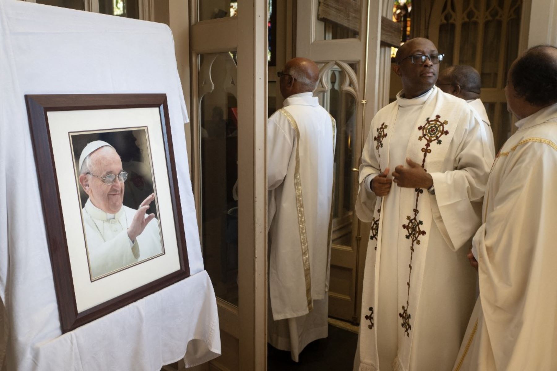 Sacerdotes católicos desfilan ante una foto del papa Francisco durante una misa en su homenaje en la catedral de Santa María en Ciudad del Cabo, el 23 de abril de 2025. Foto: AFP