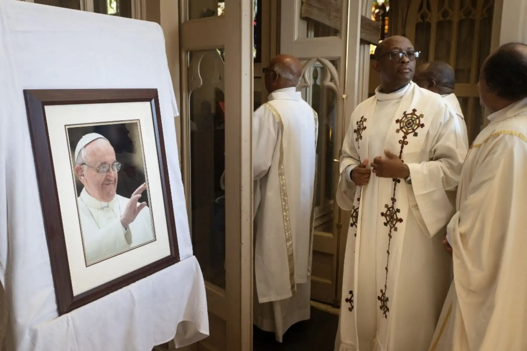 Sacerdotes católicos desfilan ante una foto del papa Francisco durante una misa en su homenaje en la catedral de Santa María en Ciudad del Cabo, el 23 de abril de 2025. Foto: AFP