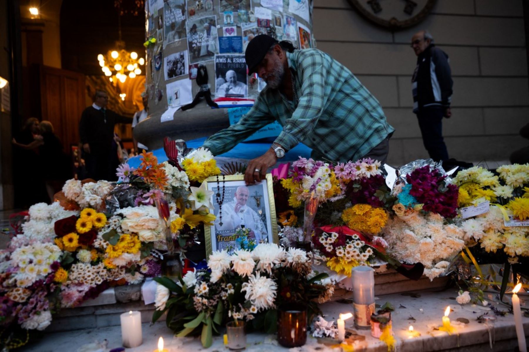 Un hombre coloca un retrato del difunto Papa Francisco en un altar improvisado frente a la Catedral de Buenos Aires tras una misa. Foto: AFP