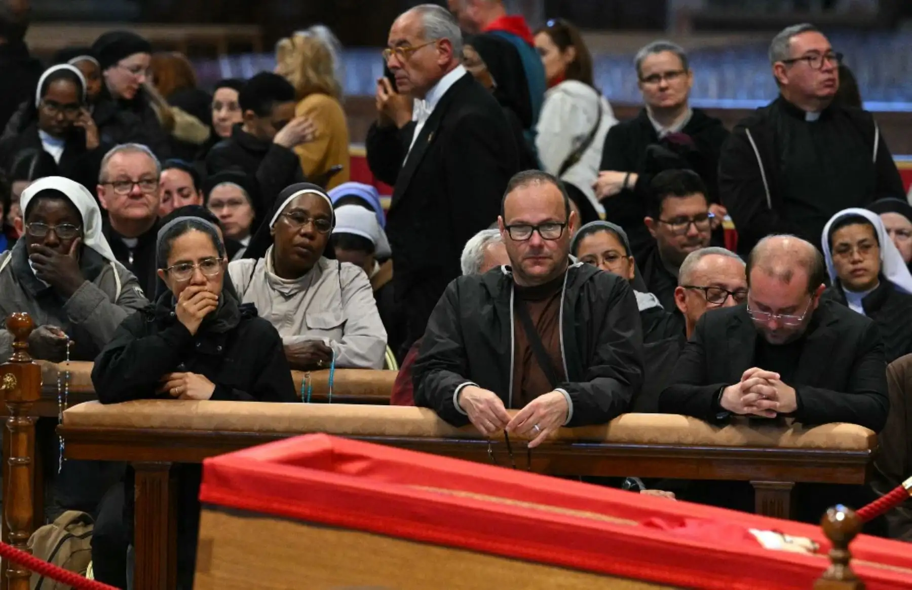 Los fieles reaccionan junto al féretro mientras rinden homenaje al difunto papa Francisco en la Basílica de San Pedro. Foto: AFP