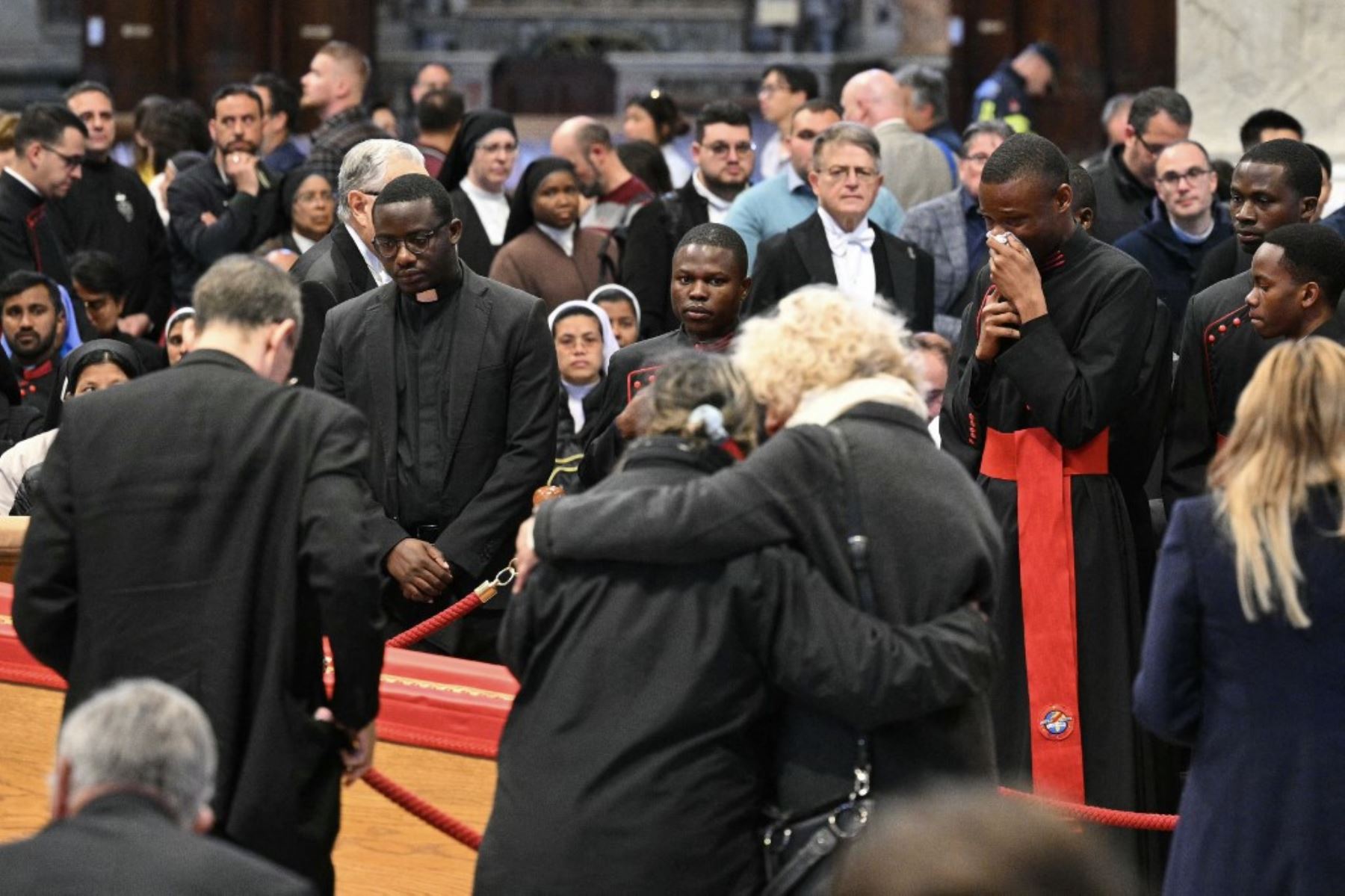 Los fieles reaccionan junto al féretro mientras rinden homenaje al difunto papa Francisco en la Basílica de San Pedro. Foto: AFP