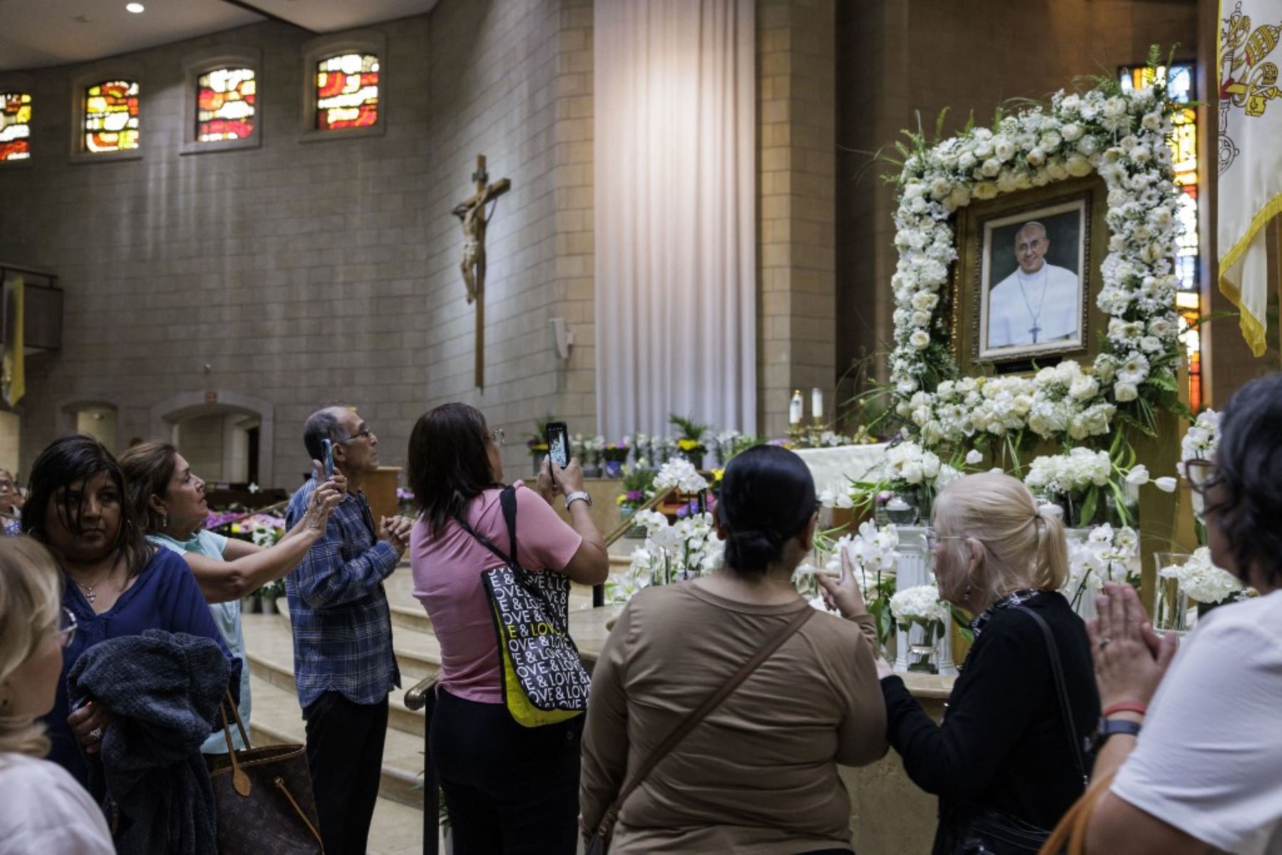 Feligreses rezan y fotografían un retrato del difunto papa Francisco tras la Misa de Sufragio Pontificio celebrada en la Basílica de Nuestra Señora de San Juan del Valle en Texas. Foto: AFP