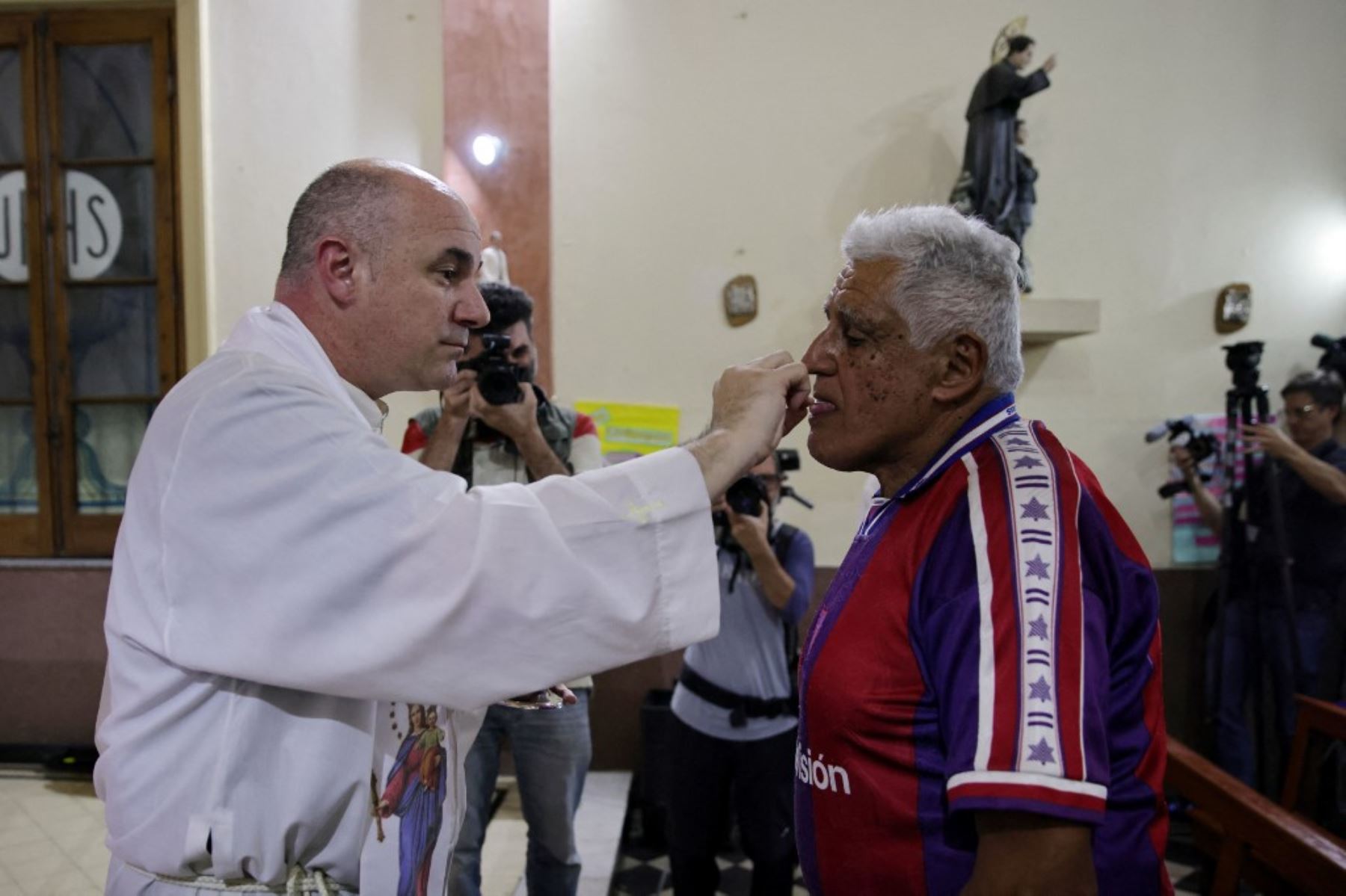 Un sacerdote da la comunión a los hinchas del club de fútbol San Lorenzo de Almagro durante una misa en memoria del difunto papa Francisco en el Oratorio San Antonio, lugar de fundación del club, en Buenos Aires. El difunto papa Francisco, Jorge Bergoglio, era hincha y socio número 88235 del club de fútbol argentino San Lorenzo. Foto: AFP