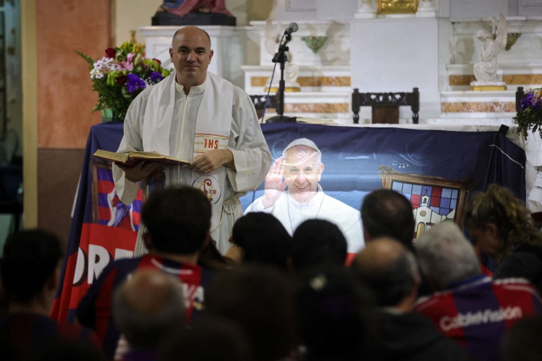 Un sacerdote habla con los hinchas del club de fútbol San Lorenzo de Almagro durante una misa en memoria del difunto Papa Francisco en el Oratorio San Antonio, lugar de fundación del club, en Buenos Aires. El difunto Papa Francisco, Jorge Bergoglio, era hincha y socio número 88235 del club de fútbol argentino San Lorenzo. Foto: AFP