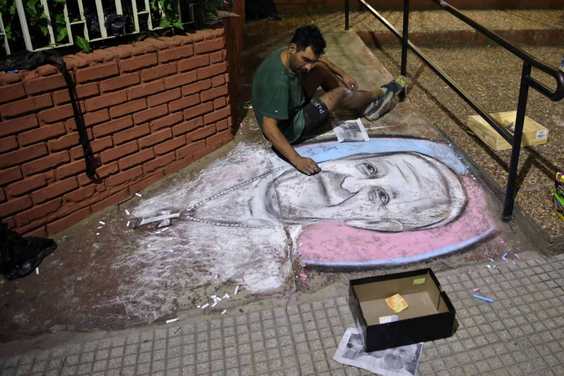 Un hombre dibuja el rostro del difunto Papa Francisco en una calle frente al Oratorio San Antonio, lugar de fundación del club de fútbol San Lorenzo, en Buenos Aires. El difunto Papa Francisco, Jorge Bergoglio, era hincha y socio número 88235 del club de fútbol argentino San Lorenzo. Foto: AFP