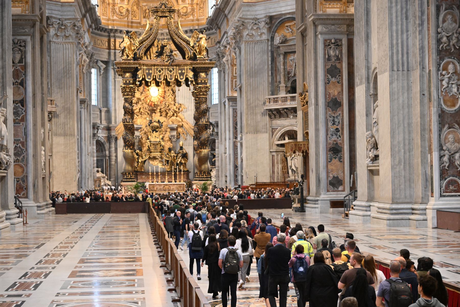 Los dolientes y visitantes hacen cola para presentar sus respetos al difunto Papa Francisco mientras yace en un ataúd en la Basílica de San Pedro en el Vaticano. AFP