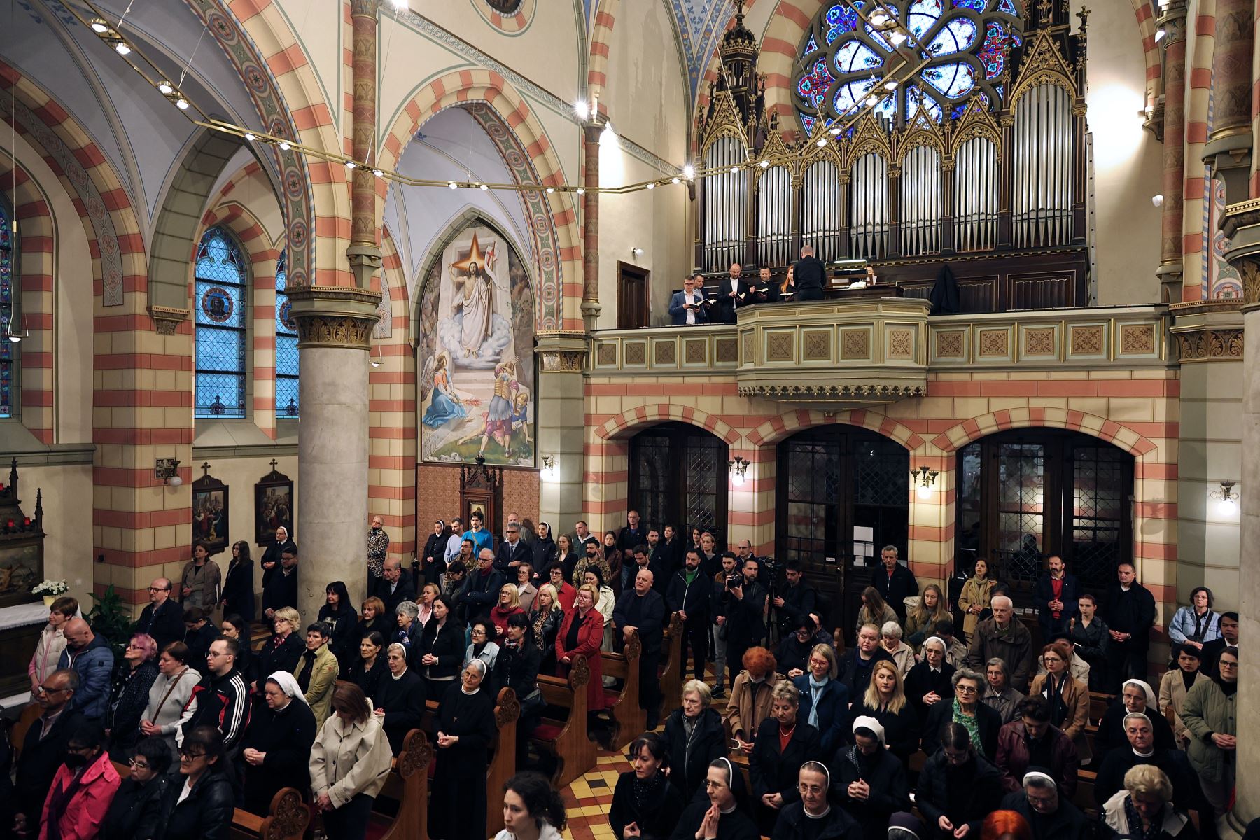 Los creyentes católicos rezan mientras asisten a un servicio vespertino dedicado al difunto Papa Francisco dentro de la Catedral del Corazón de Jesús de Sarajevo. AFP