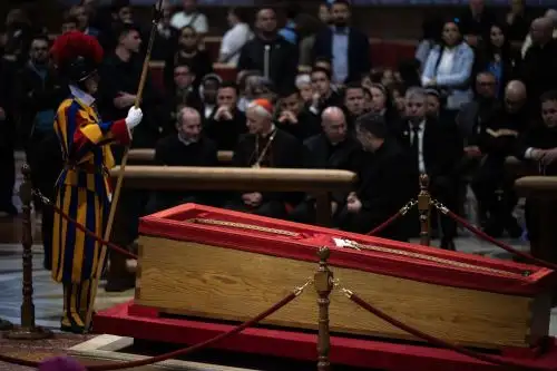 Un guardia suizo permanece junto al ataúd del difunto Papa Francisco mientras yace en estado en la Basílica de San Pedro en el Vaticano, un día antes del funeral del Papa, el 25 de abril de 2025. Foto: AFP