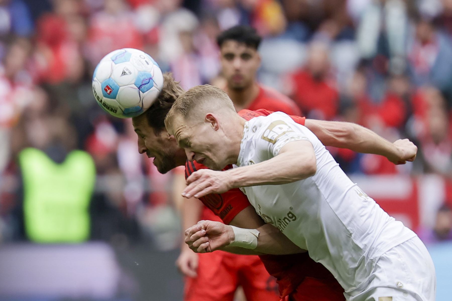 Harry Kane del Múnich en acción contra Andreas Hanche-Olsen del Mainz durante el partido de fútbol de la Bundesliga alemana entre el FC Bayern Múnich y el 1. FSV Mainz 05 en Múnich, Alemania, el 26 de abril de 2025. Foto: EFE