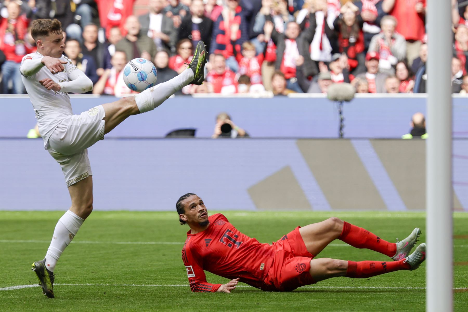Leroy Sane del Múnich en acción contra Nikolas Veratschnig del Mainz  durante el partido de fútbol de la Bundesliga alemana entre el FC Bayern Múnich y el FSV Mainz 05 en Múnich, Alemania, el 26 de abril de 2025. Foto: EFE