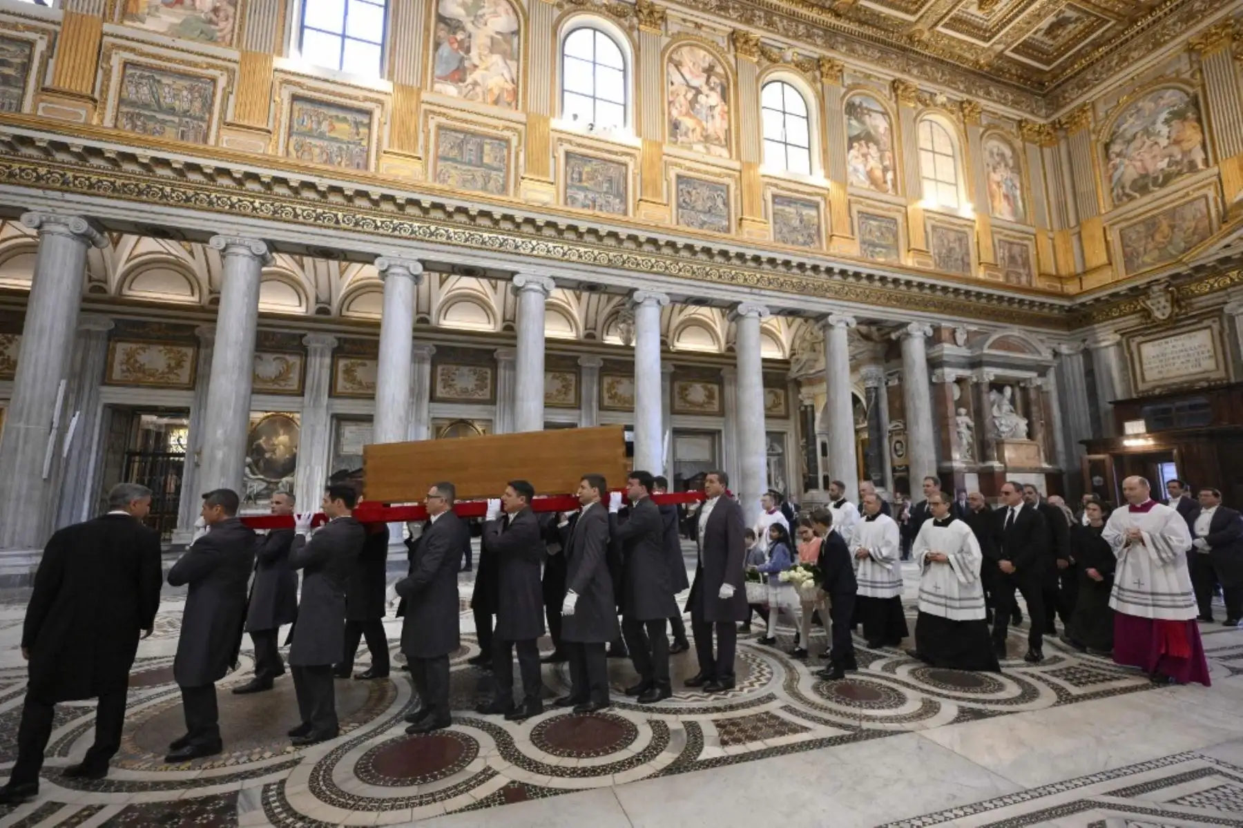 Esta fotografía, tomada y publicada el 26 de abril de 2025 por The Vatican Media, muestra a los portadores del féretro llevando el ataúd del difunto Papa Francisco al final de su servicio funeral, dentro de la Basílica de Santa María la Mayor, el lugar de descanso final del Papa, en Roma. Foto: AFP