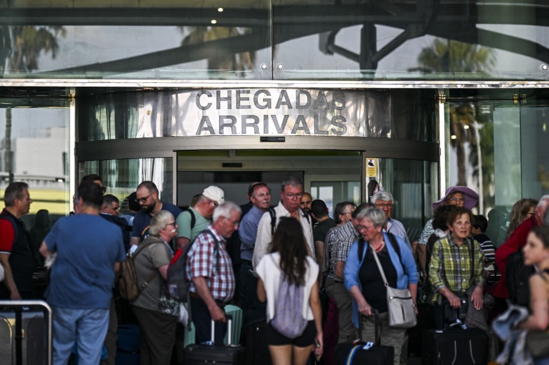 Personas con su equipaje esperan fuera del aeropuerto Humberto Delgado tras un apagón general en Lisboa el 28 de abril de 2025. Hoy se produjo un corte de electricidad en toda España y Portugal, lo que provocó cortes de telefonía móvil e internet, interrupciones en los trenes y personas atrapadas en ascensores, según informaron las autoridades. Foto: AFP