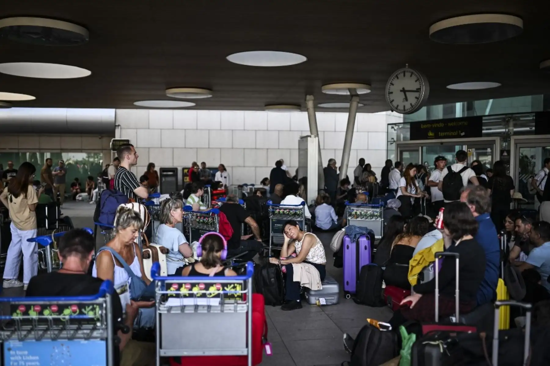 Personas con su equipaje esperan fuera del aeropuerto Humberto Delgado tras un apagón general en Lisboa el 28 de abril de 2025. Hoy se produjo un corte de electricidad en toda España y Portugal, lo que provocó cortes de telefonía móvil e internet, interrupciones en los trenes y personas atrapadas en ascensores, según informaron las autoridades. Foto: AFP