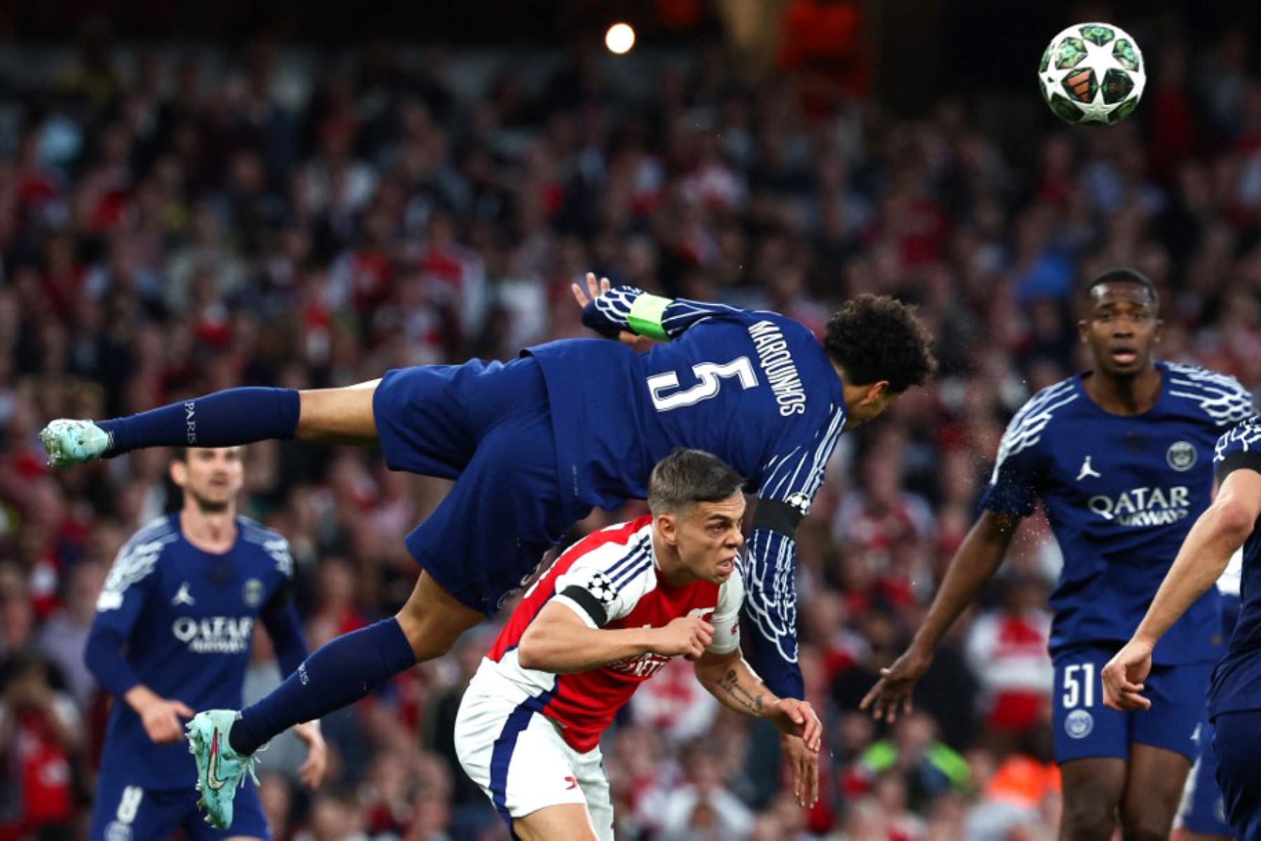 El defensor brasileño Marquinhos del Paris Saint-Germain cabecea el balón mientras salta sobre el mediocampista belga Leandro Trossard del Arsenal durante el partido de ida de la semifinal de la Liga de Campeones de la UEFA entre el Arsenal y el Paris Saint-Germain (PSG) en el Emirates Stadium en el norte de Londres, el 29 de abril de 2025. Foto: AFP