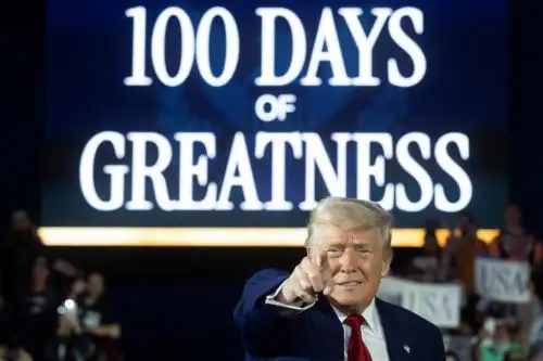 "Cien días de grandeza" reza la inscripción detrás del presidente Donald Trump. Foto: AFP