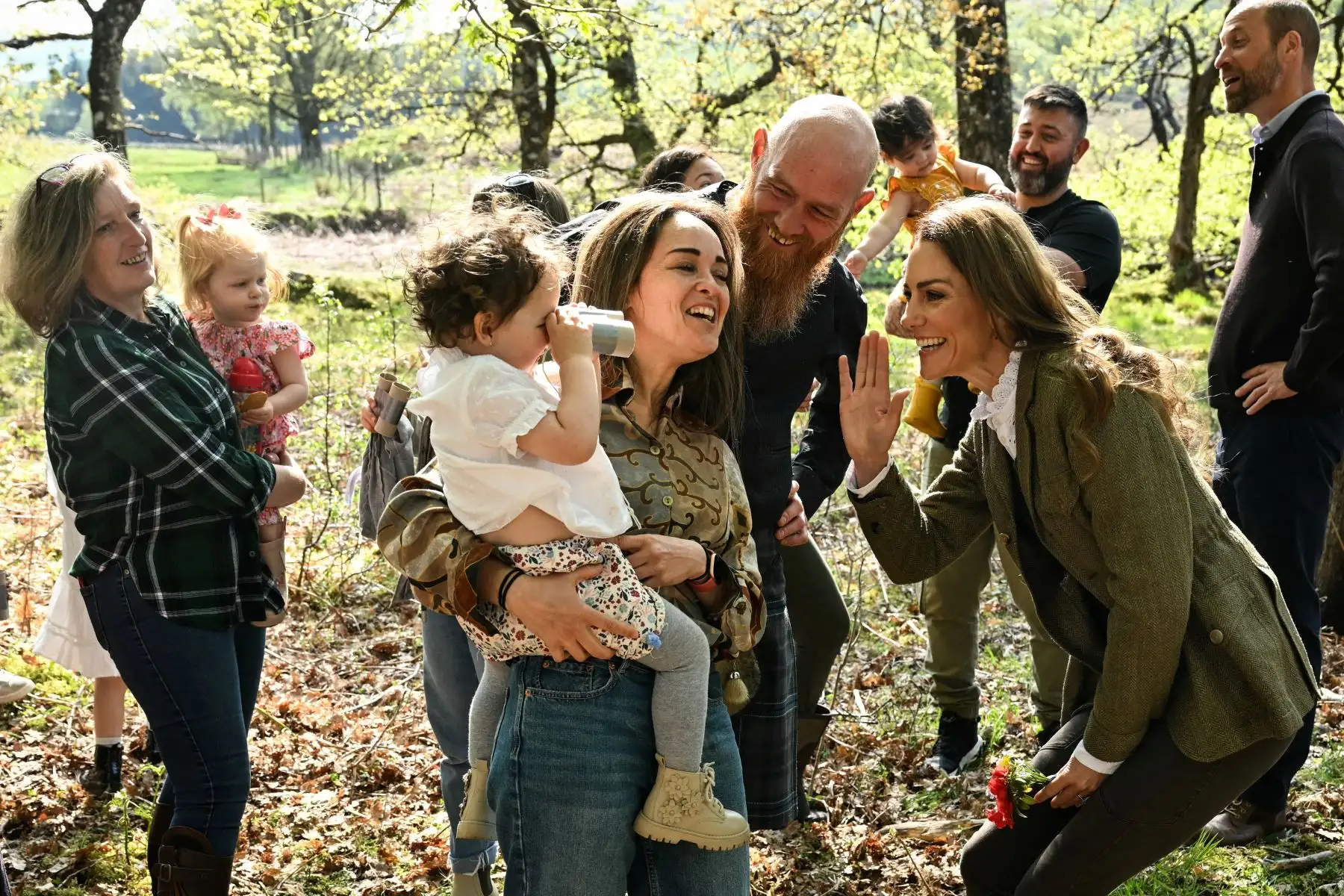 La Princesa Kate de Gales  bromea con los niños del grupo Ardura Acorns y su familia durante una visita al Bosque Comunitario de Ardura para destacar la importancia de proteger y defender el medio ambiente natural, como parte de su viaje de dos días a la Isla de Mull, en el oeste de Escocia. AFP