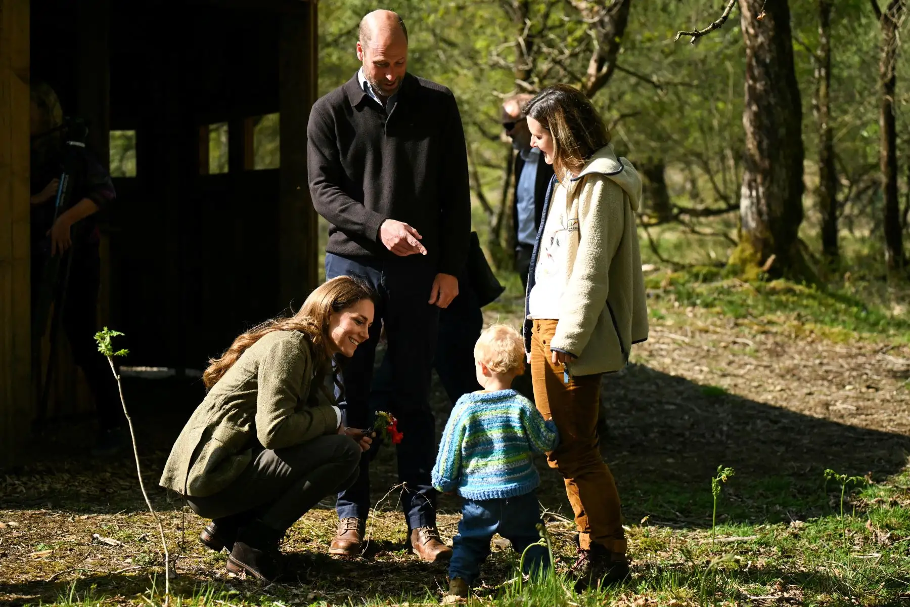 La Princesa Kate de Gales y el Príncipe Guillermo de Gales de Gran Bretaña  hablan con un niño del grupo Ardura Acorns y su familia durante una visita al Bosque Comunitario de Ardura para destacar la importancia de proteger y defender el medio ambiente natural, como parte de su viaje de dos días a la Isla de Mull, en el oeste de Escocia. AFP