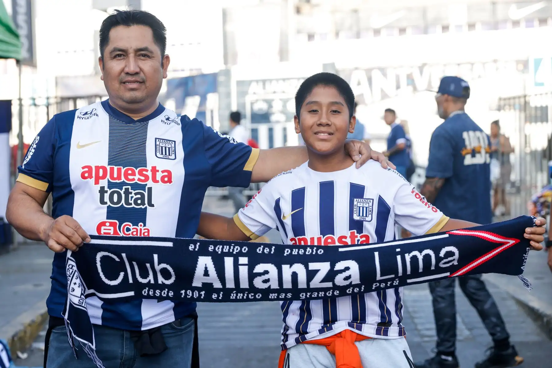 A pocos minutos del inicio del duelo entre Alianza Lima y Cienciano por la jornada 11 de la Liga 1, los alrededores del estadio Alejandro Villanueva vibran con el fervor blanquiazul. Familias enteras, hinchas apasionados y vendedores ambulantes llenan las calles, entre aromas de anticuchos, polladas y picarones. La salsa, las banderas azules y el ambiente festivo reflejan la mística Alianza Lima. Foto: ANDINA/Luis Iparraguirre
