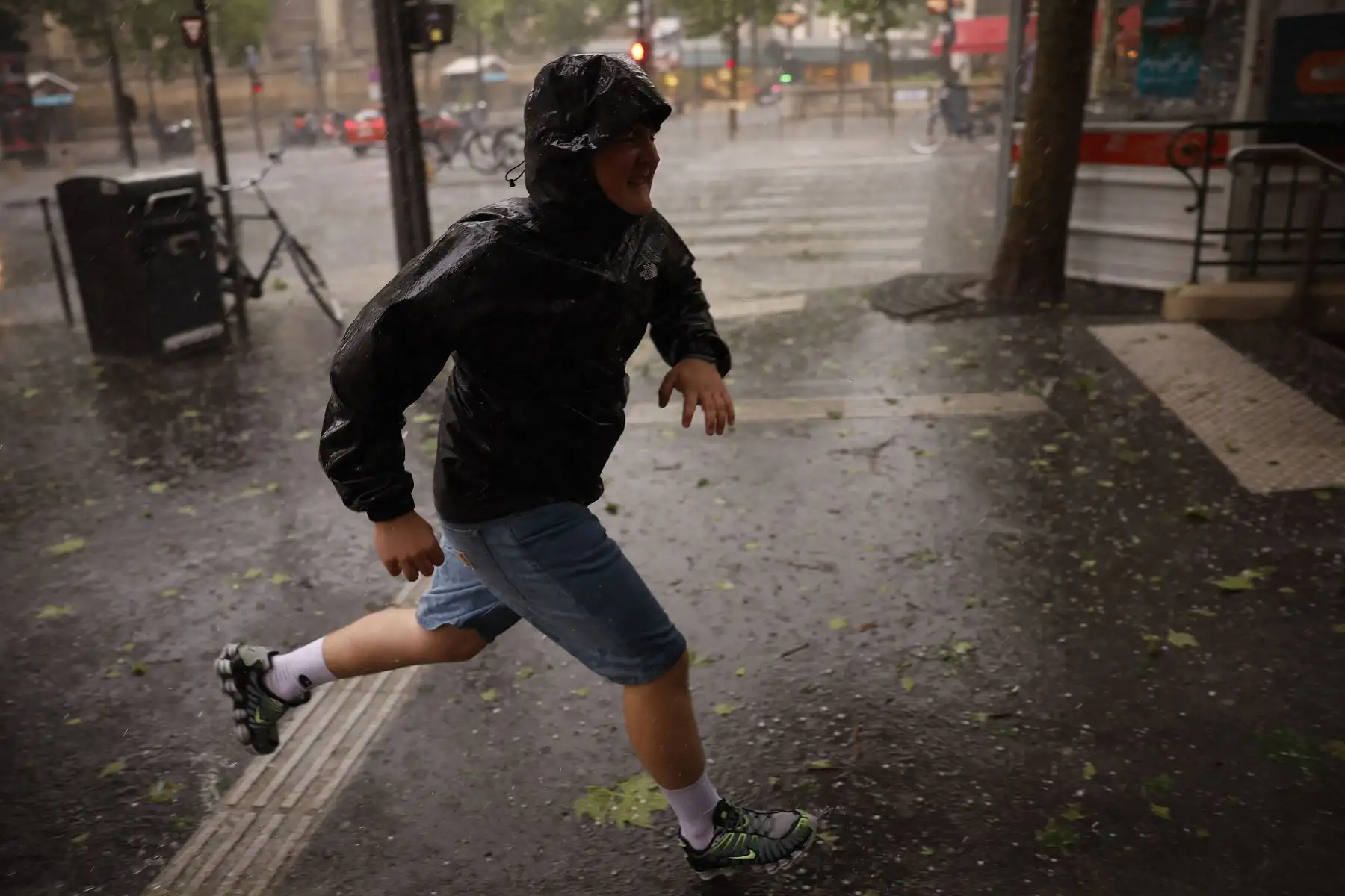 Una persona busca refugio del granizo durante una tormenta de granizo en París. AFP