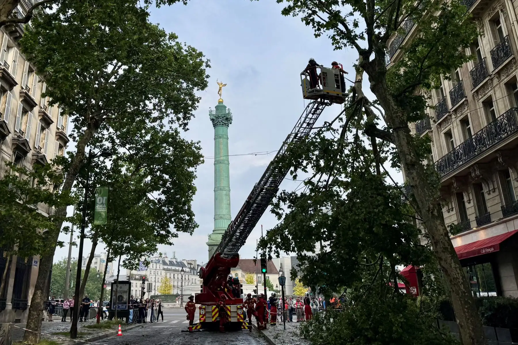 Los bomberos franceses retiran una gran rama rota que aún estaba adherida a un árbol en una avenida que conduce a la Place de la Bastille después de una violenta tormenta de granizo, en París. La tormenta eléctrica y la granizada que azotaron París la tarde del 3 de mayo causaron interrupciones muy menores en la red de transporte de la región parisina, lo que provocó el cierre temporal de cuatro estaciones de metro debido a las inundaciones, dijo RATP. AFP