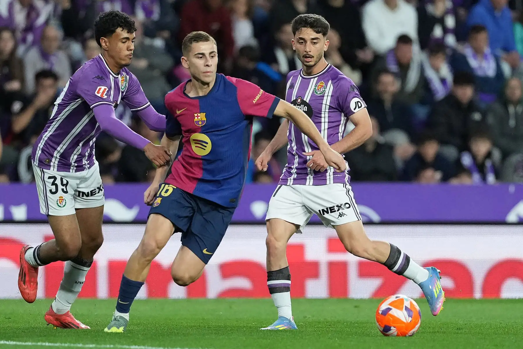 El defensa marroquí del Real Valladolid, Adam Aznou, y el centrocampista español  del Barcelona, ​​Fermín López, luchan por el balón durante el partido de fútbol de la liga española entre el Real Valladolid FC y el FC Barcelona en el estadio José Zorrilla en Valladolid.
Foto: AFP