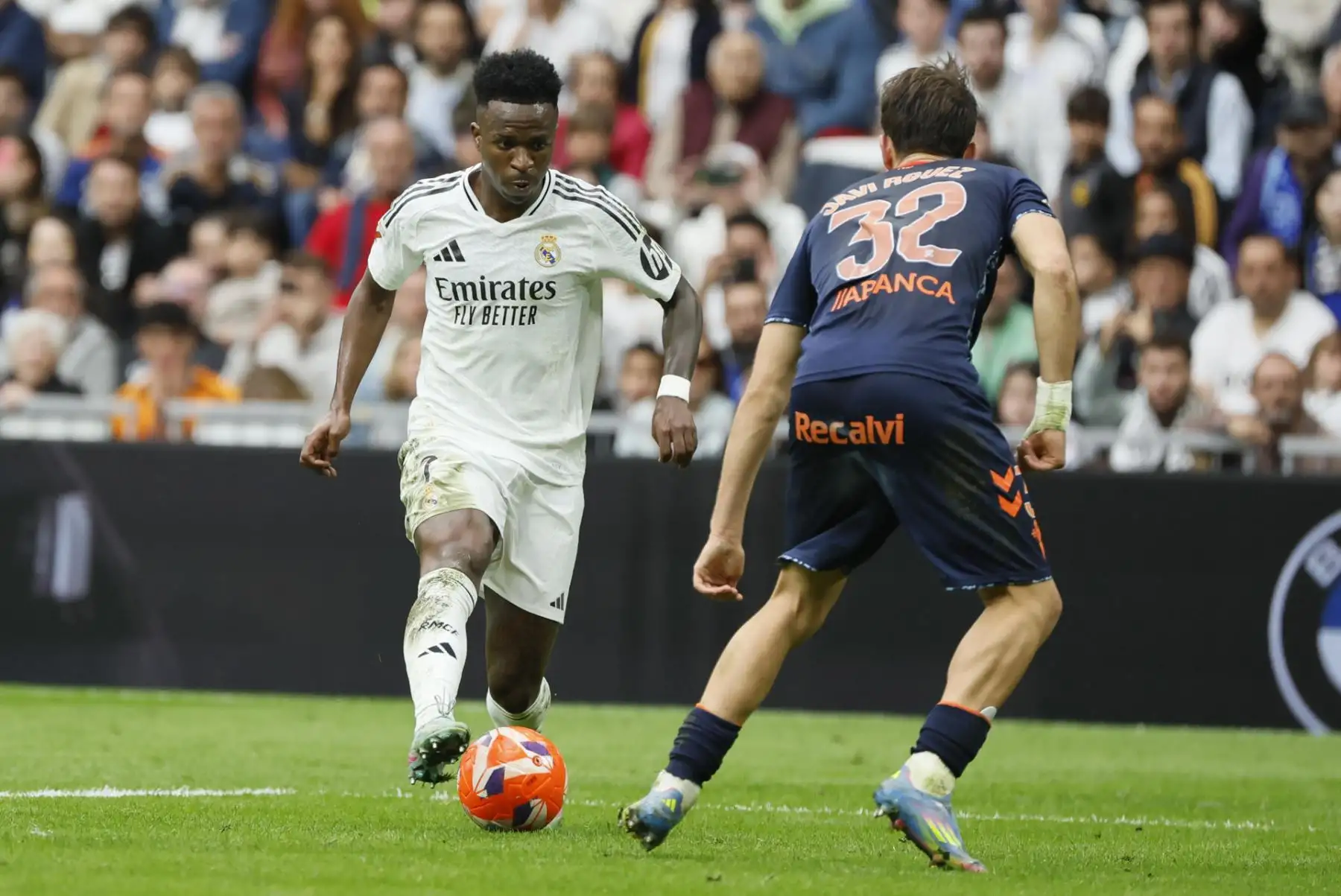 El delantero brasileño del Real Madrid Vini Jr. lucha por el balón con el centrocampista del Celta de Vigo Javi Rodríguez durante el partido entre el Real Madrid y el Celta. EFE