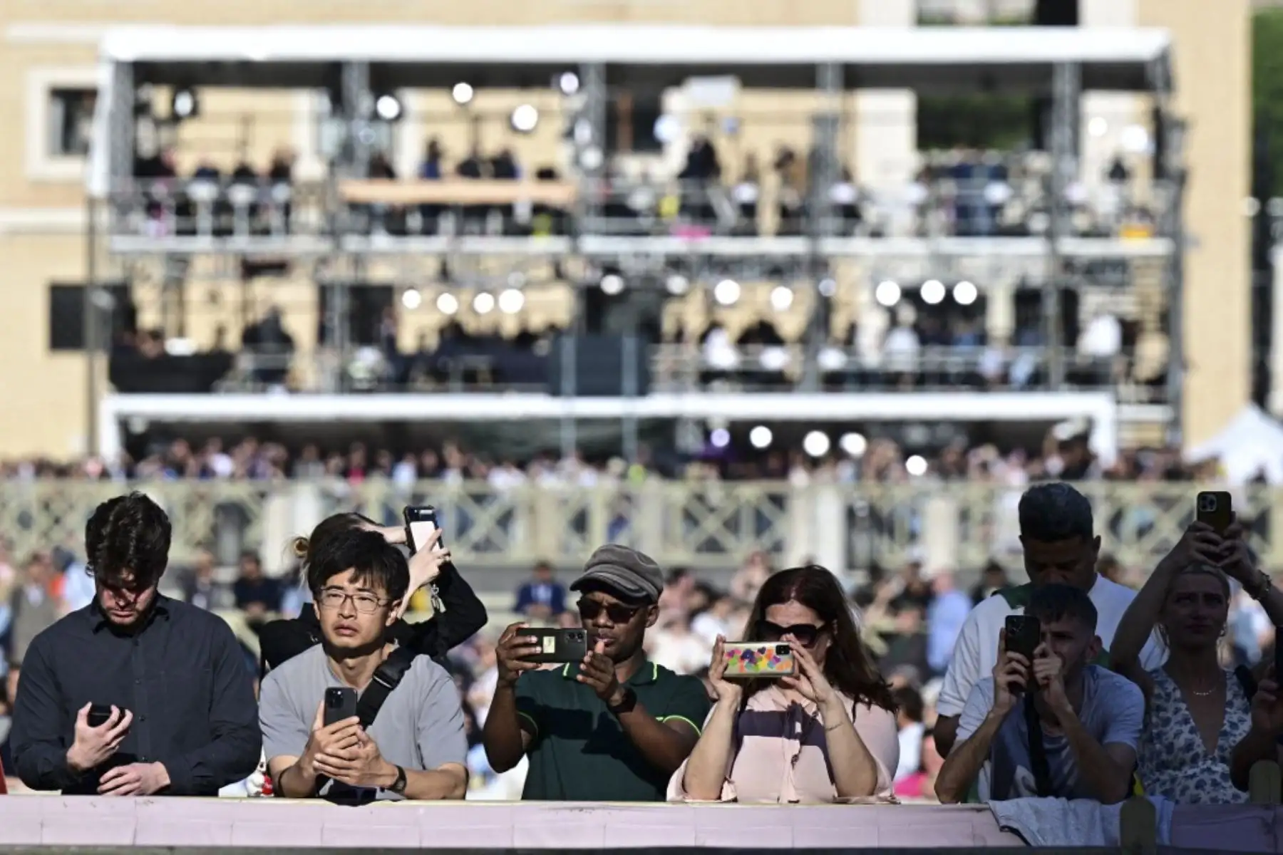 Fieles permanecen en la Plaza de San Pedro mientras comienza el cónclave para elegir al nuevo Papa en el Vaticano

Foto: AFP