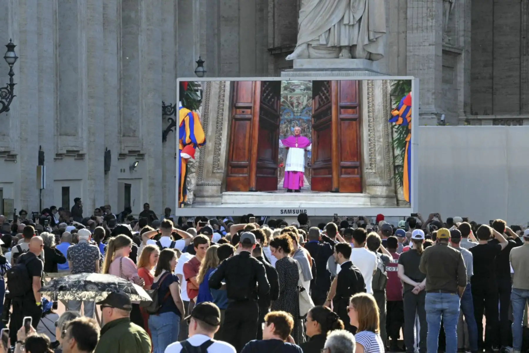 Los fieles observan una pantalla gigante que muestra imágenes de Diego Giovanni Ravelli, Maestro de las Celebraciones Litúrgicas Pontificias, cerrando las puertas de la Capilla Sixtina mientras comienza el cónclave para elegir a un nuevo Papa, en la Plaza de San Pedro en el Vaticano.

Foto: AFP