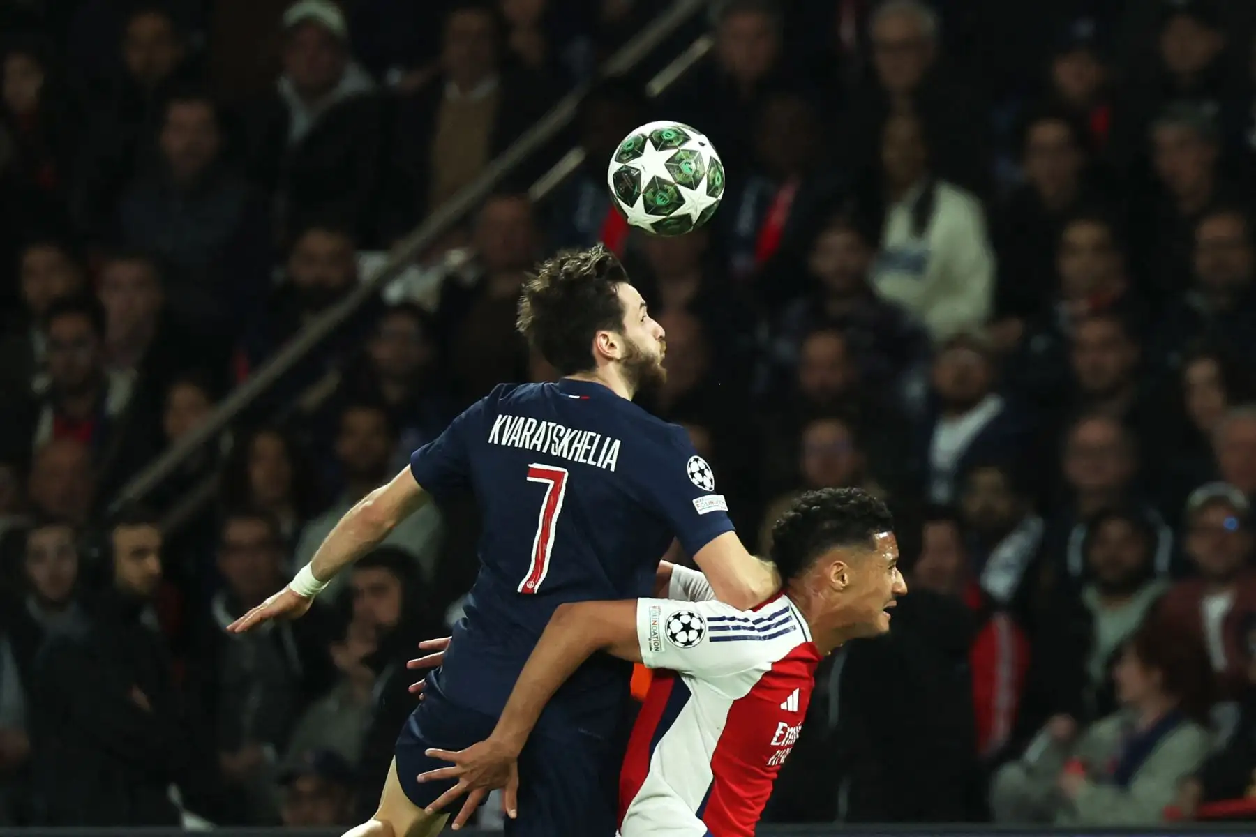 El delantero georgiano del Paris Saint-Germain, Khvicha Kvaratskhelia, cabecea el balón junto al defensor francés del Arsenal, William Saliba, durante el partido de vuelta de la semifinal de la UEFA Champions League entre el Paris Saint-Germain (PSG) y el Arsenal en el estadio Parc des Princes en París, el 7 de mayo de 2025. Foto: AFP