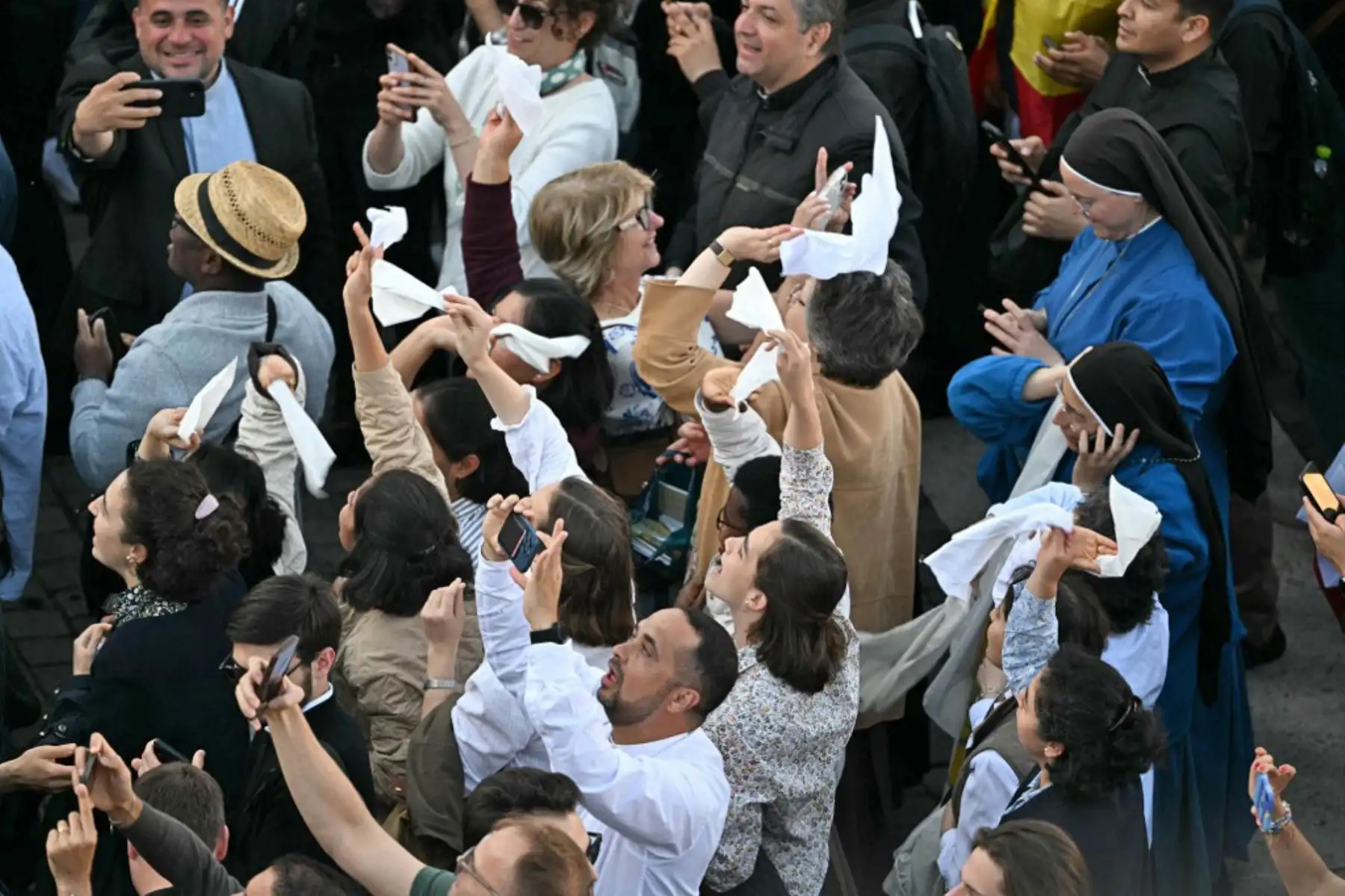 La gente reacciona y ondea banderas del Vaticano mientras una columna de humo blanco, anuncia que los cardenales eligieron un nuevo papa durante su cónclave en el Vaticano el 8 de mayo de 2025. Foto: AFP